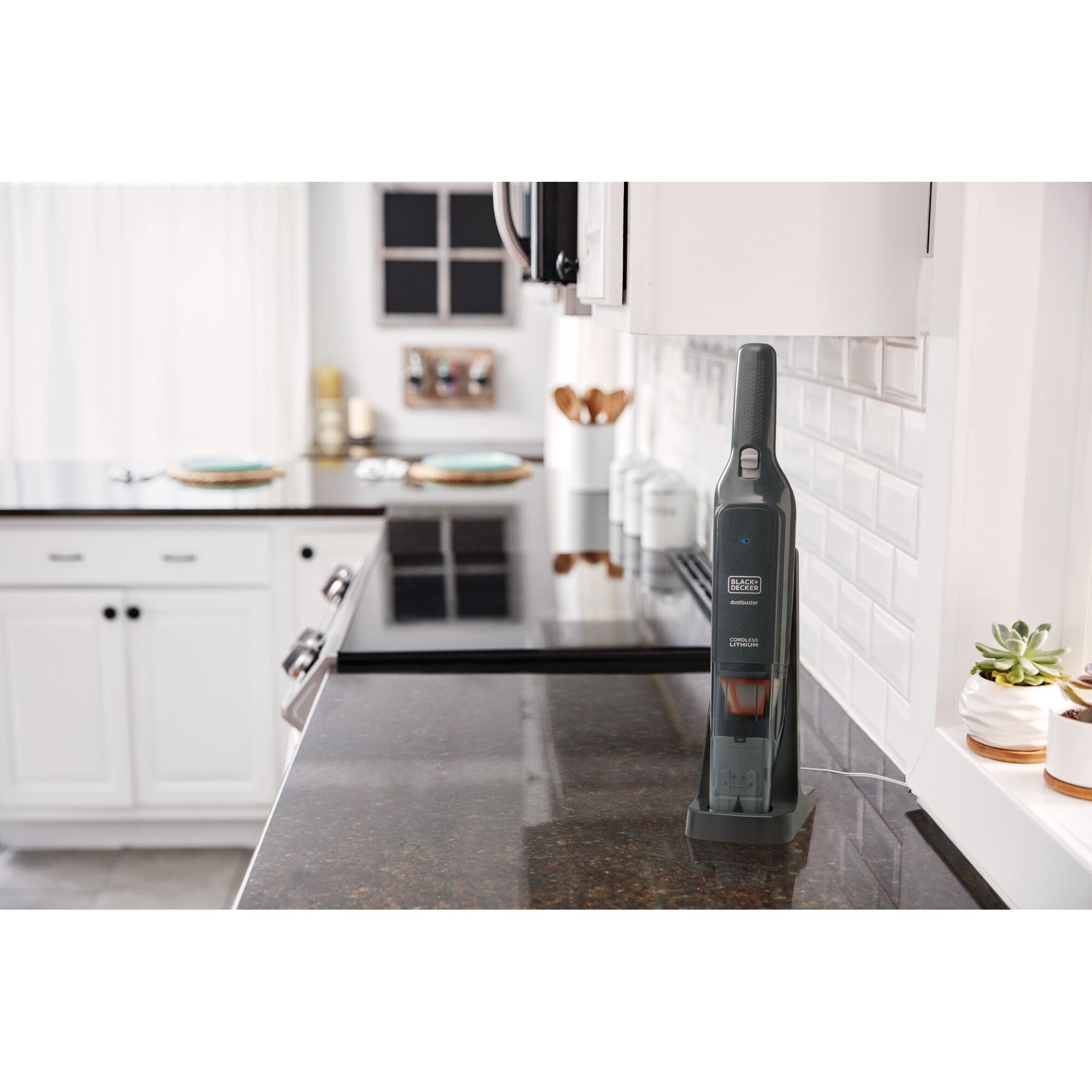 BLACKDECKER HLVC320B handheld vacuum cleaner on kitchen countertop, upright on charging base.