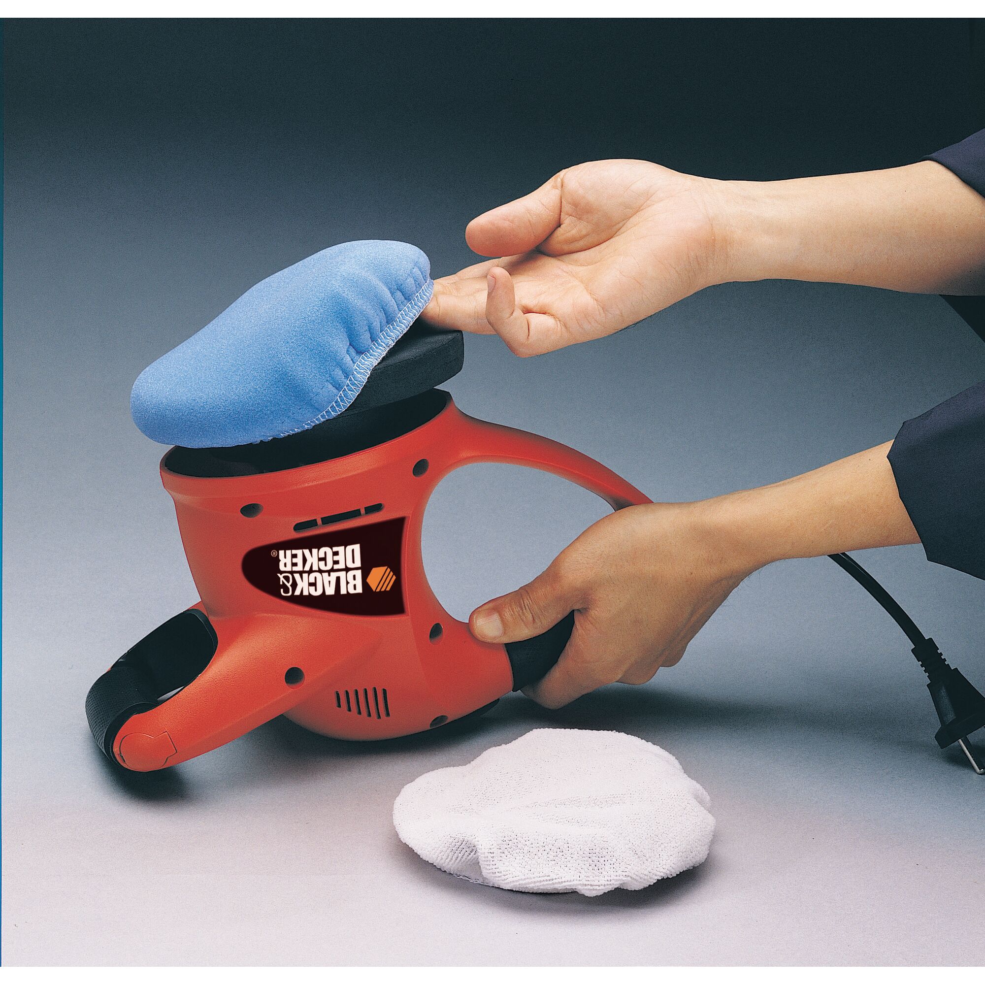 BLACKDECKER KP600 red handheld polisher with blue pad cover being attached, spare white pad shown.
