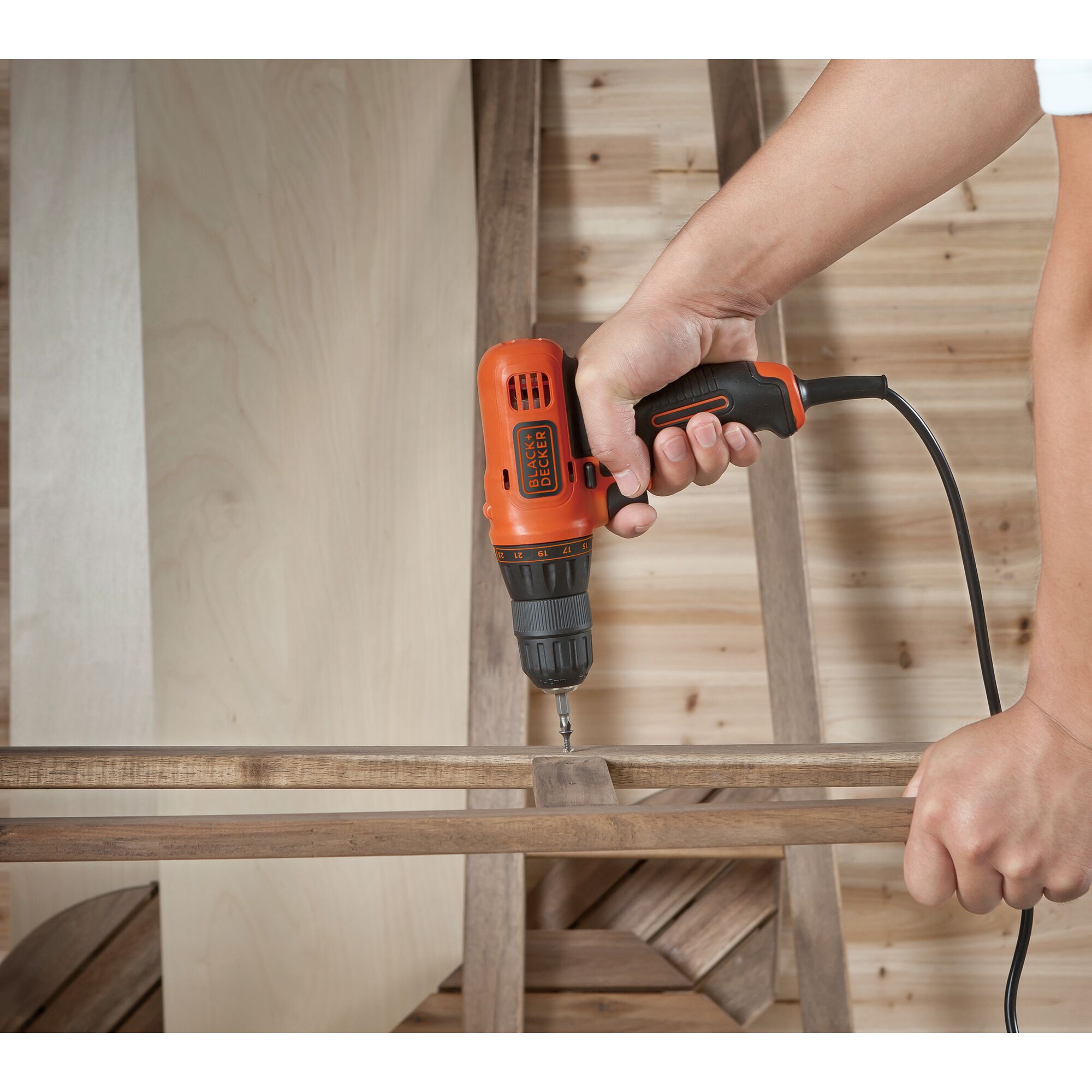 BLACKDECKER KR112 corded drill used on wood, side angle, orange and black color.
