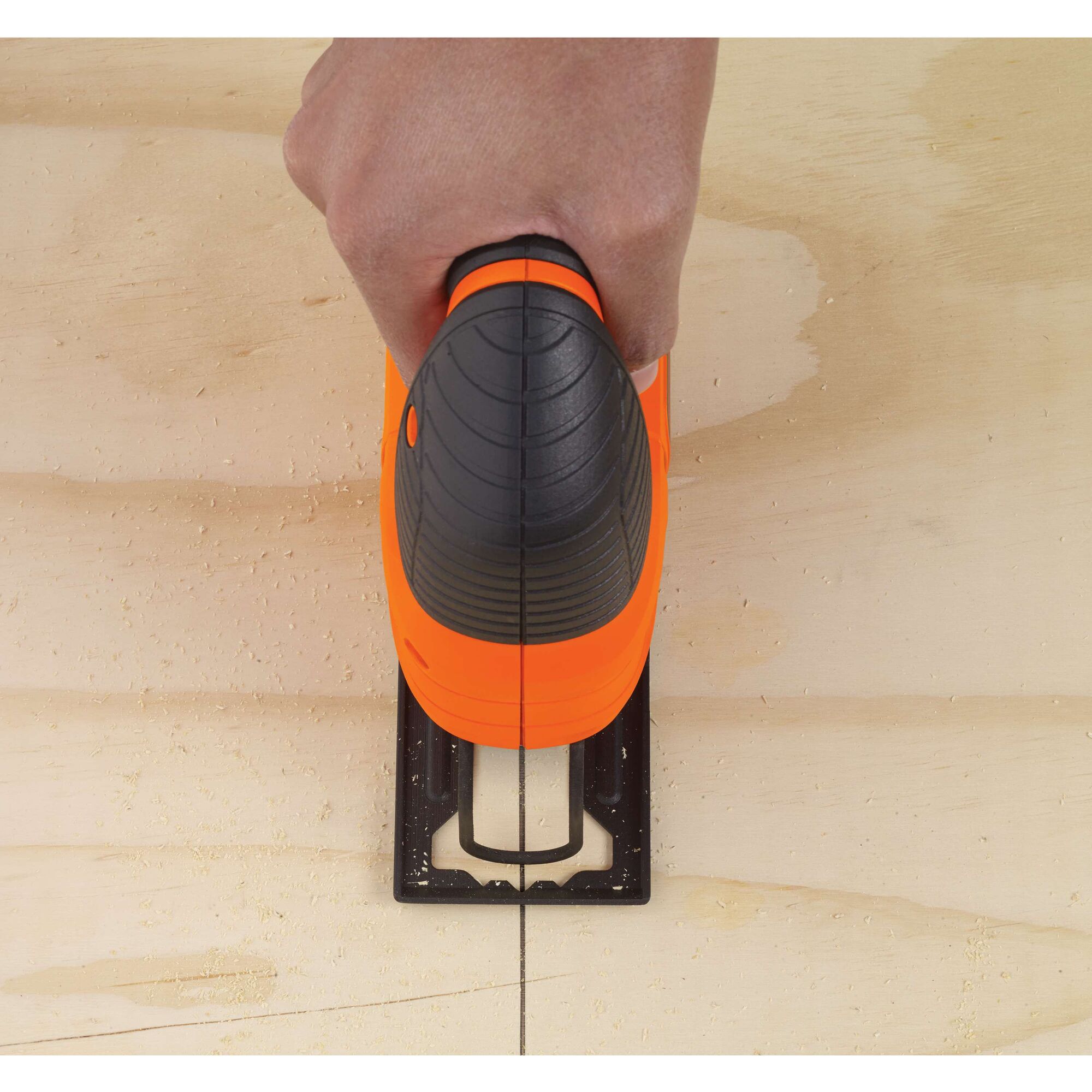 BLACKDECKER KS501 jigsaw cutting wood, top view showing orange and black handle.