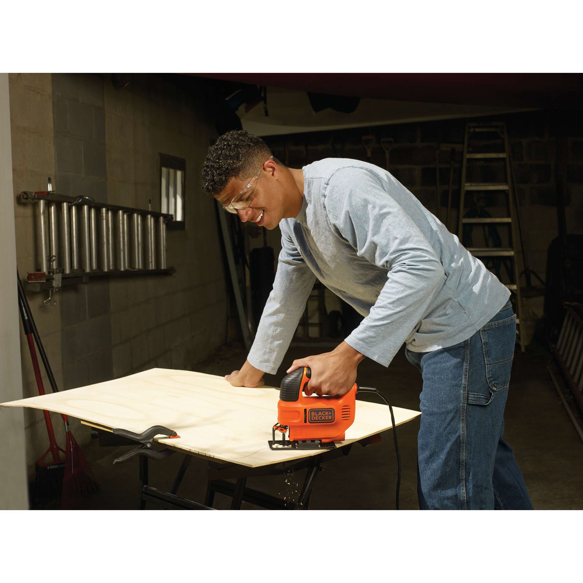 BLACKDECKER KS701E jigsaw cutting wood on workbench in workshop setting.