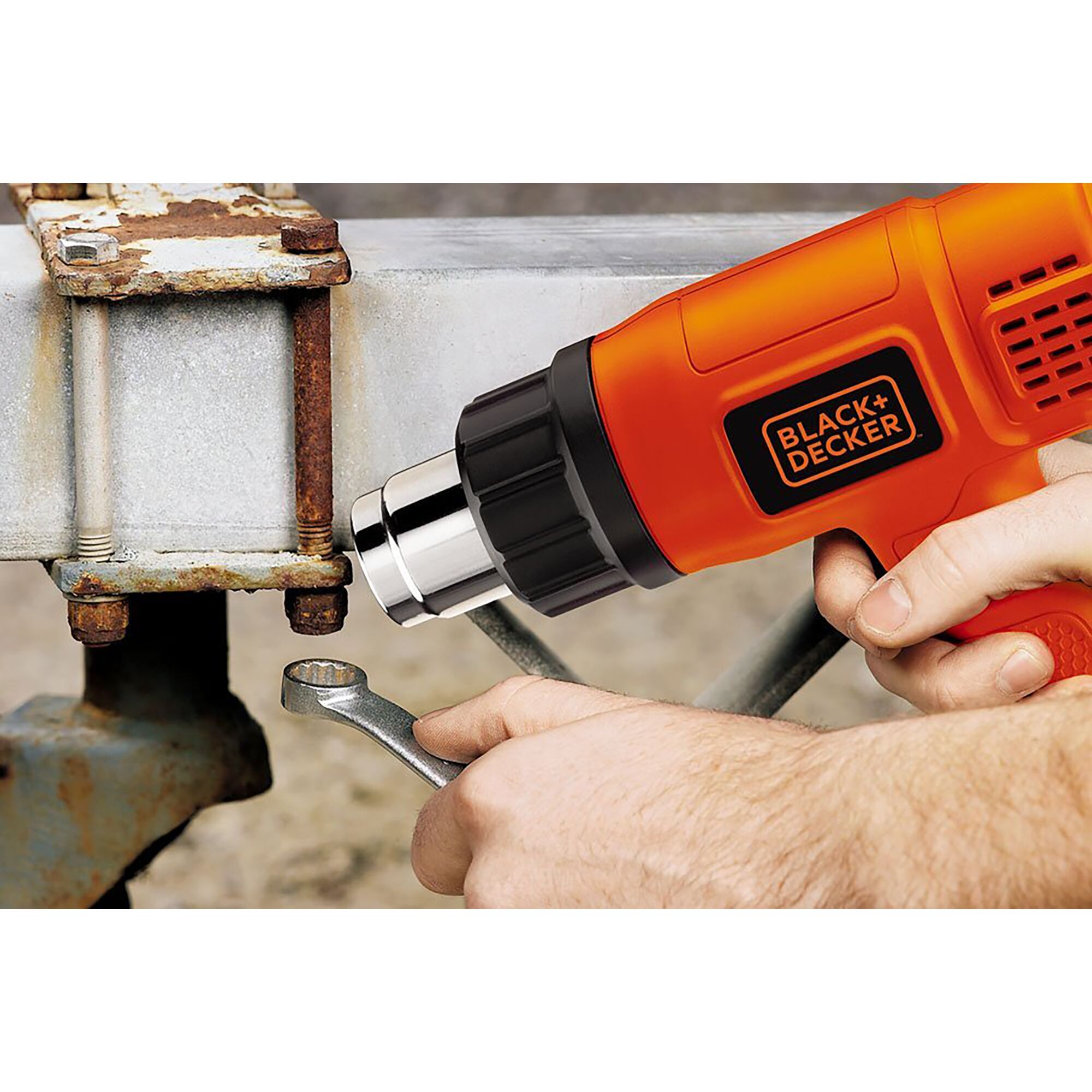 BLACK+DECKER KX1800 heat gun being used on rusty bolt with wrench, close-up photography.
