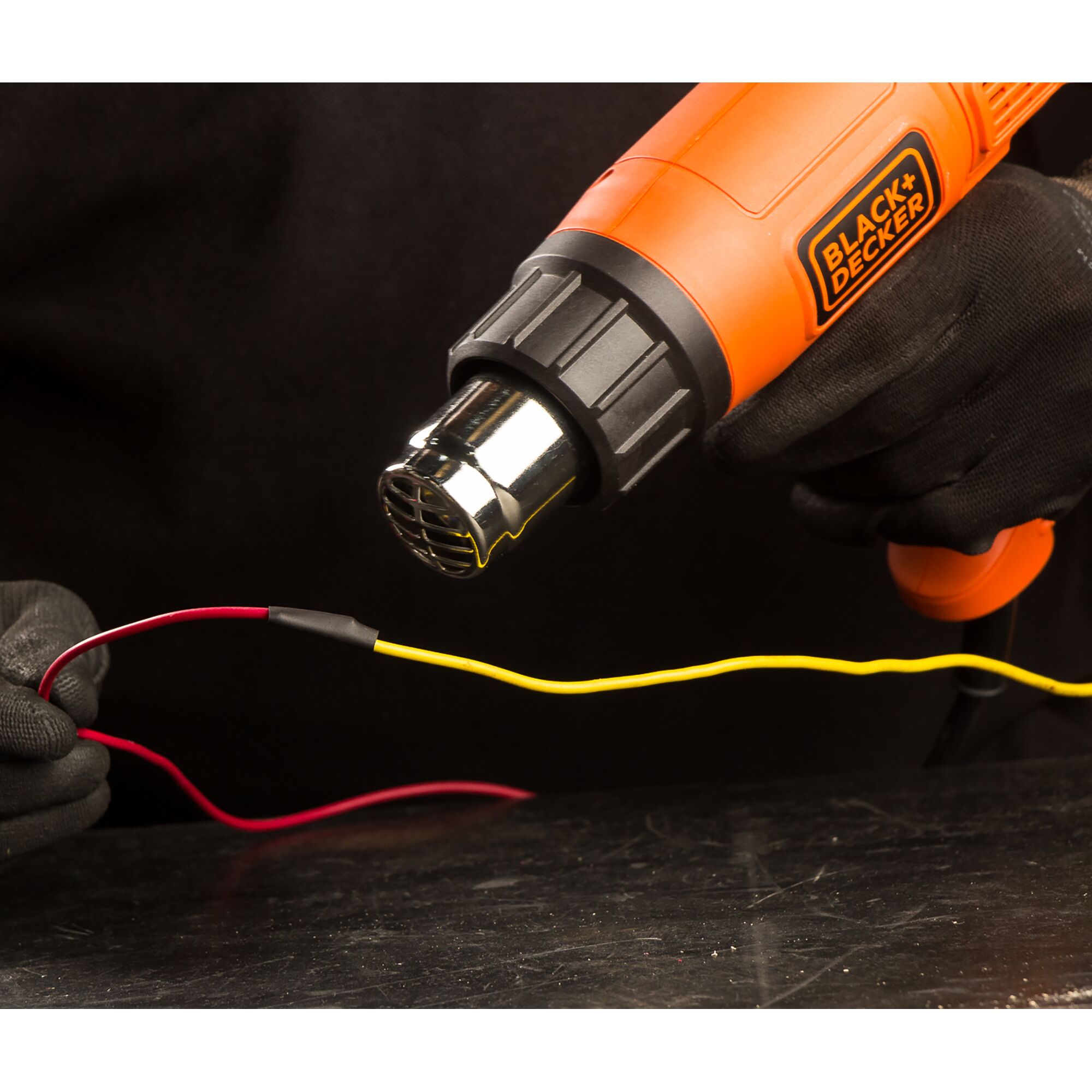 BLACK+DECKER KX1800 heat gun used to shrink tubing on wires, close-up angle, product photography.