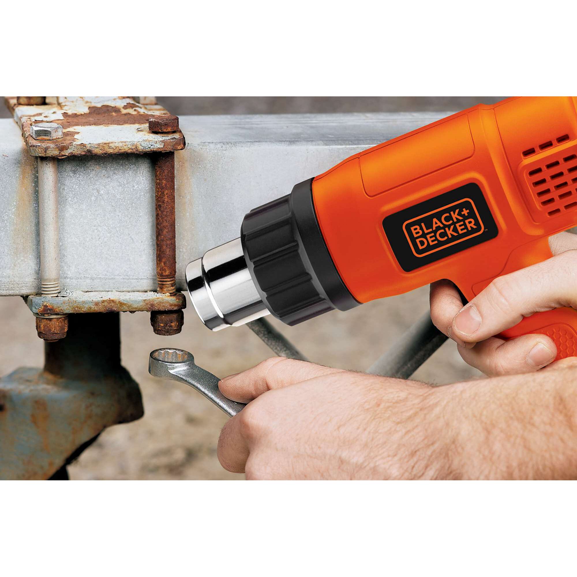 BLACK+DECKER heat gun KX1800 being used on a rusted bolt with a wrench, close-up photography.
