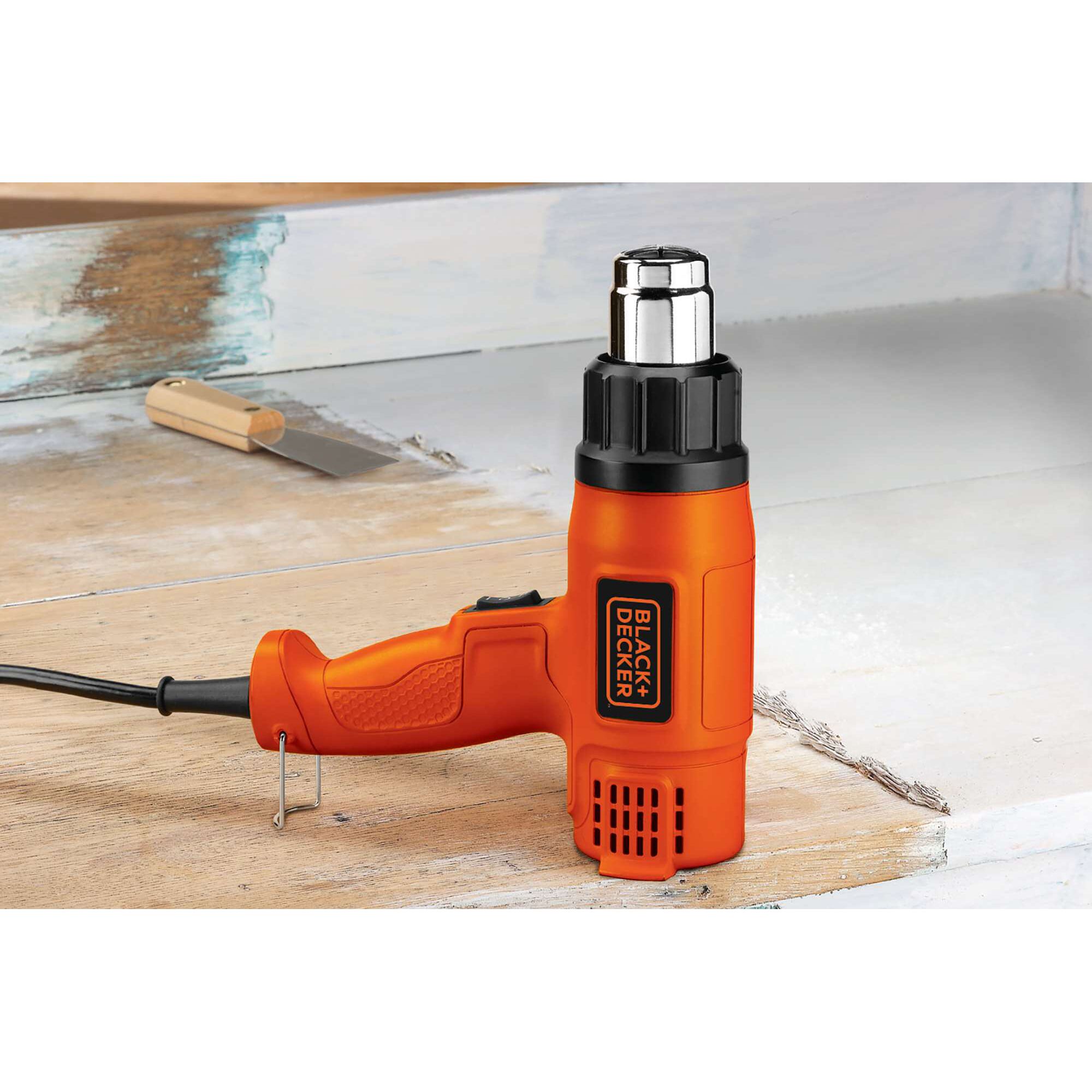 BLACKDECKER KX1800 orange heat gun on wooden surface, handle and nozzle visible, product category photography.