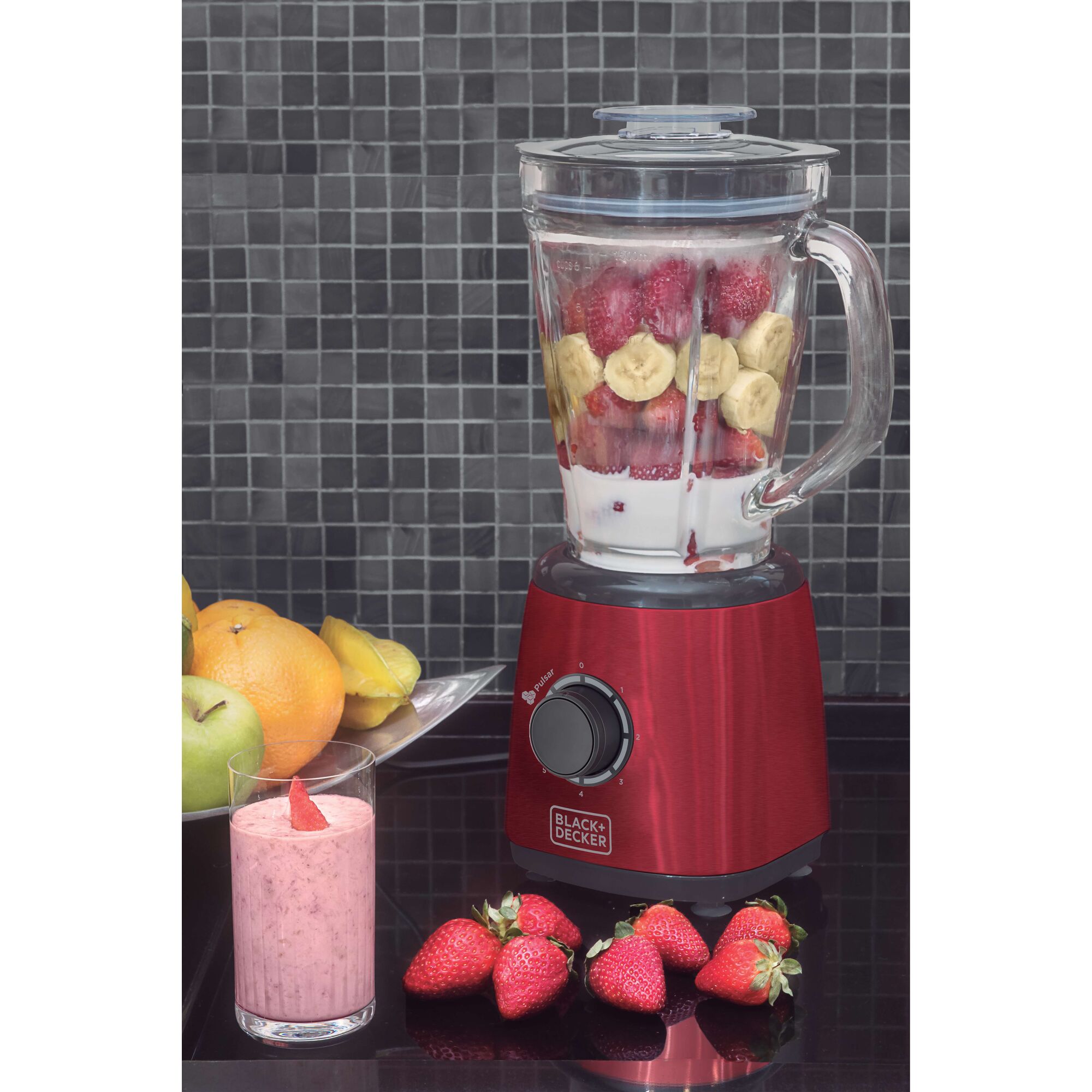 BLACKDECKER L600V red blender with strawberries, bananas, and milk, smoothie and fruits on countertop.