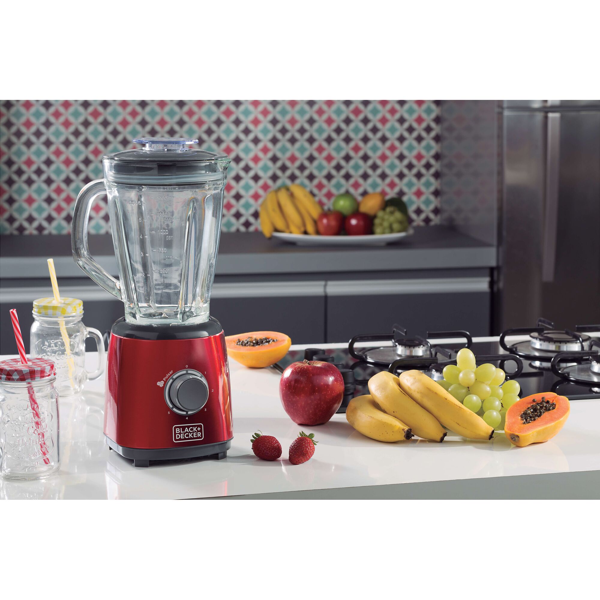 BLACKDECKER L600V red blender on kitchen counter with assorted fresh fruits and glass jars, front angle.