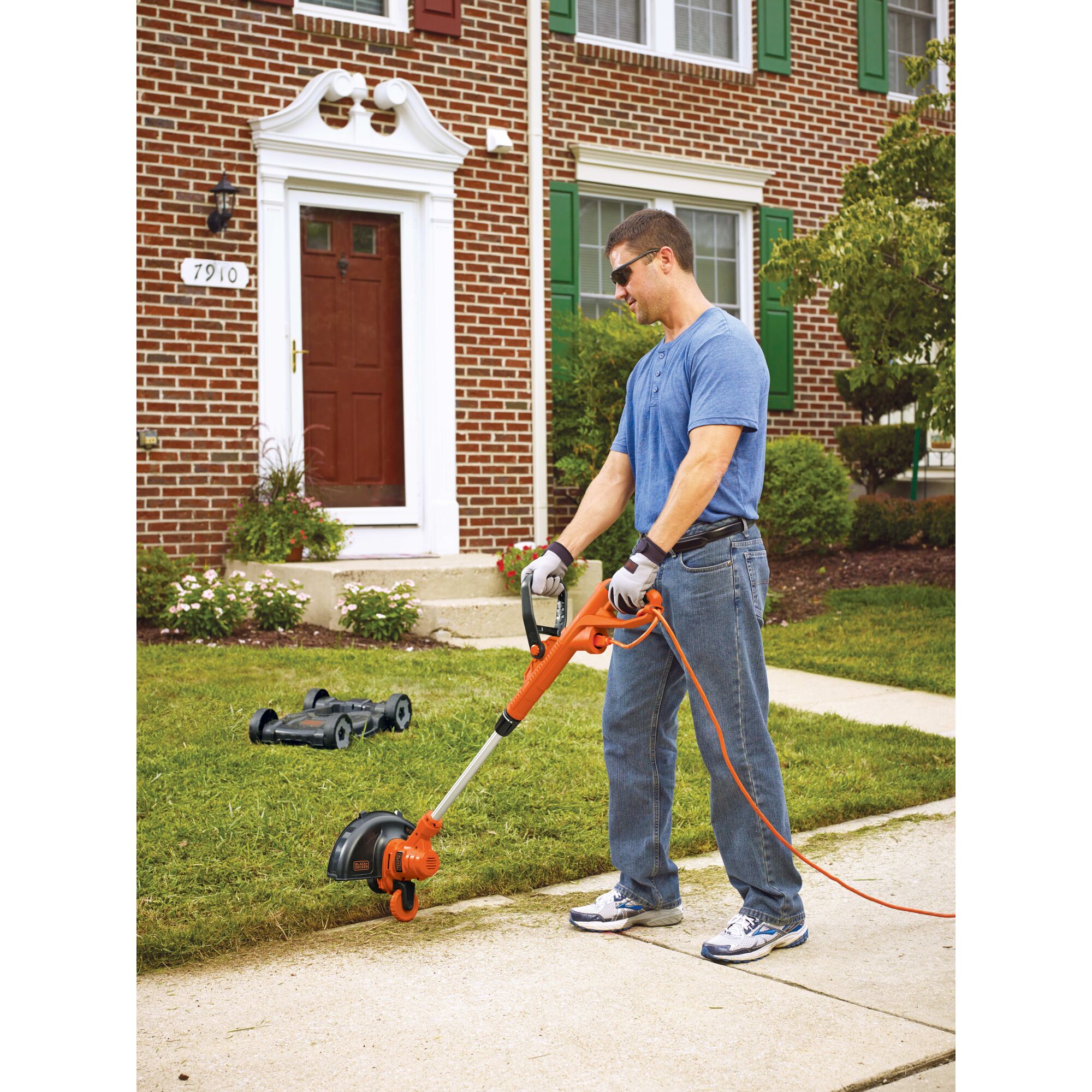 A man is using a BLACK+DECKER String Trimmer/Edger for making edges of the garden.