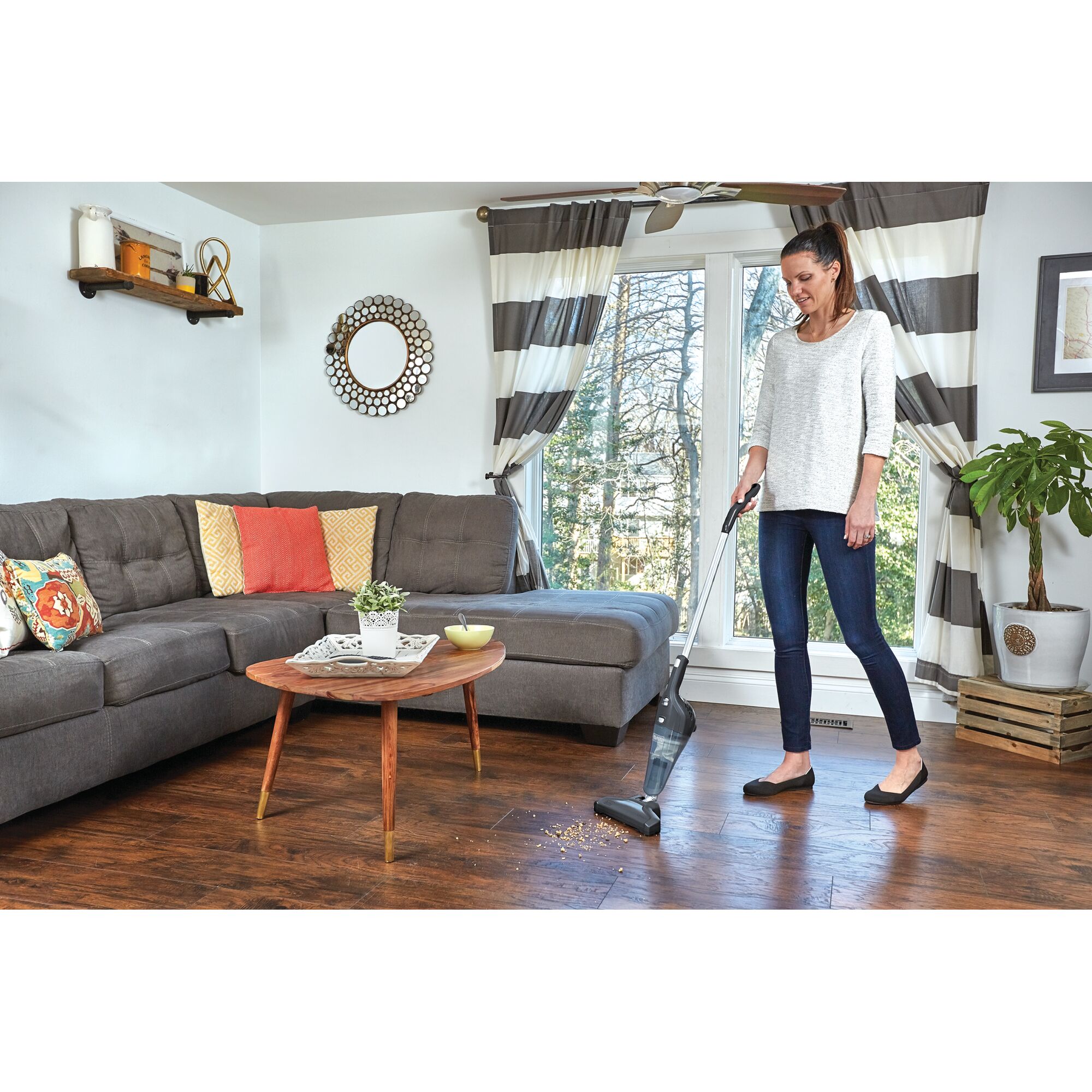 BLACKDECKER NSVA315J stick vacuum cleaning hardwood floor in modern living room, side angle.