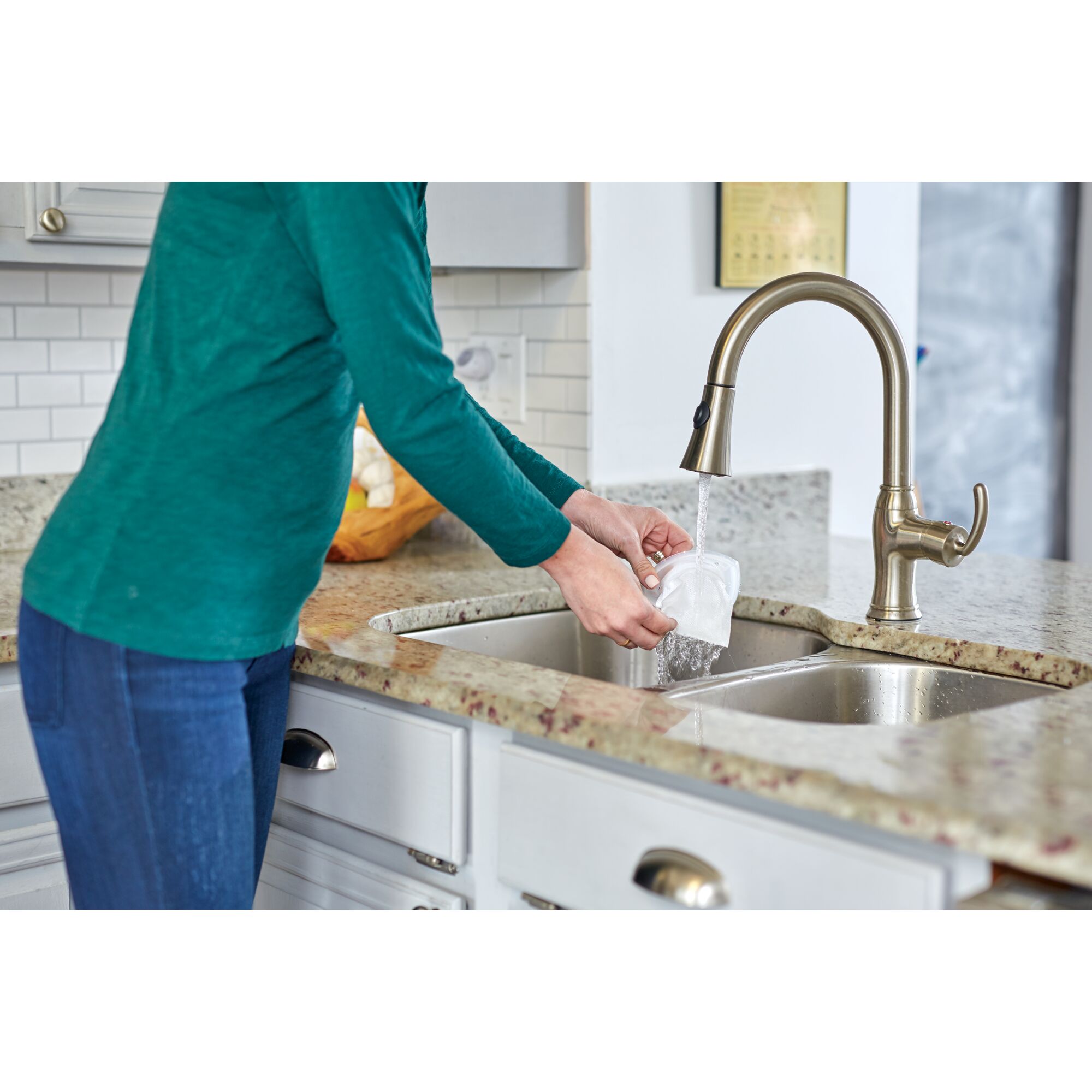 BLACKDECKER NSVA315J filter being rinsed under faucet in kitchen sink, product photography.