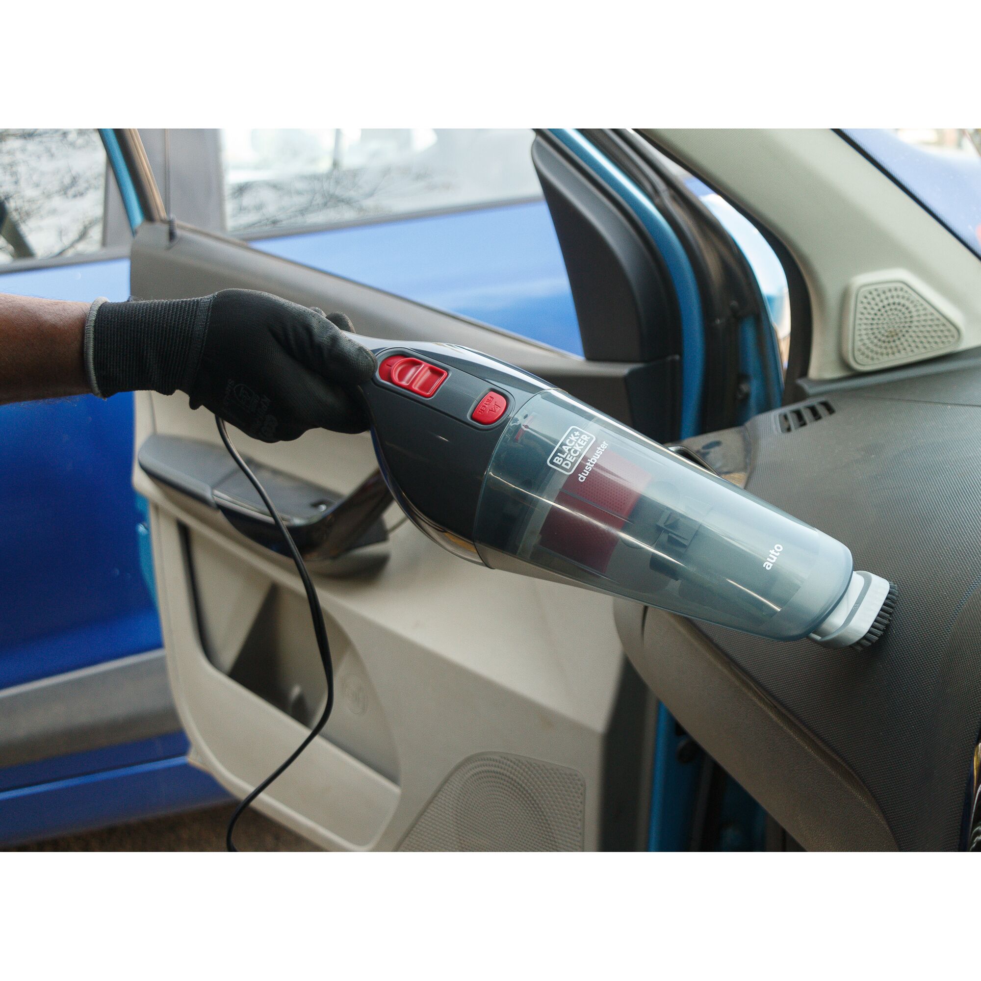 BLACKDECKER NV1200AV handheld car vacuum in use on vehicle dashboard, black and red design.