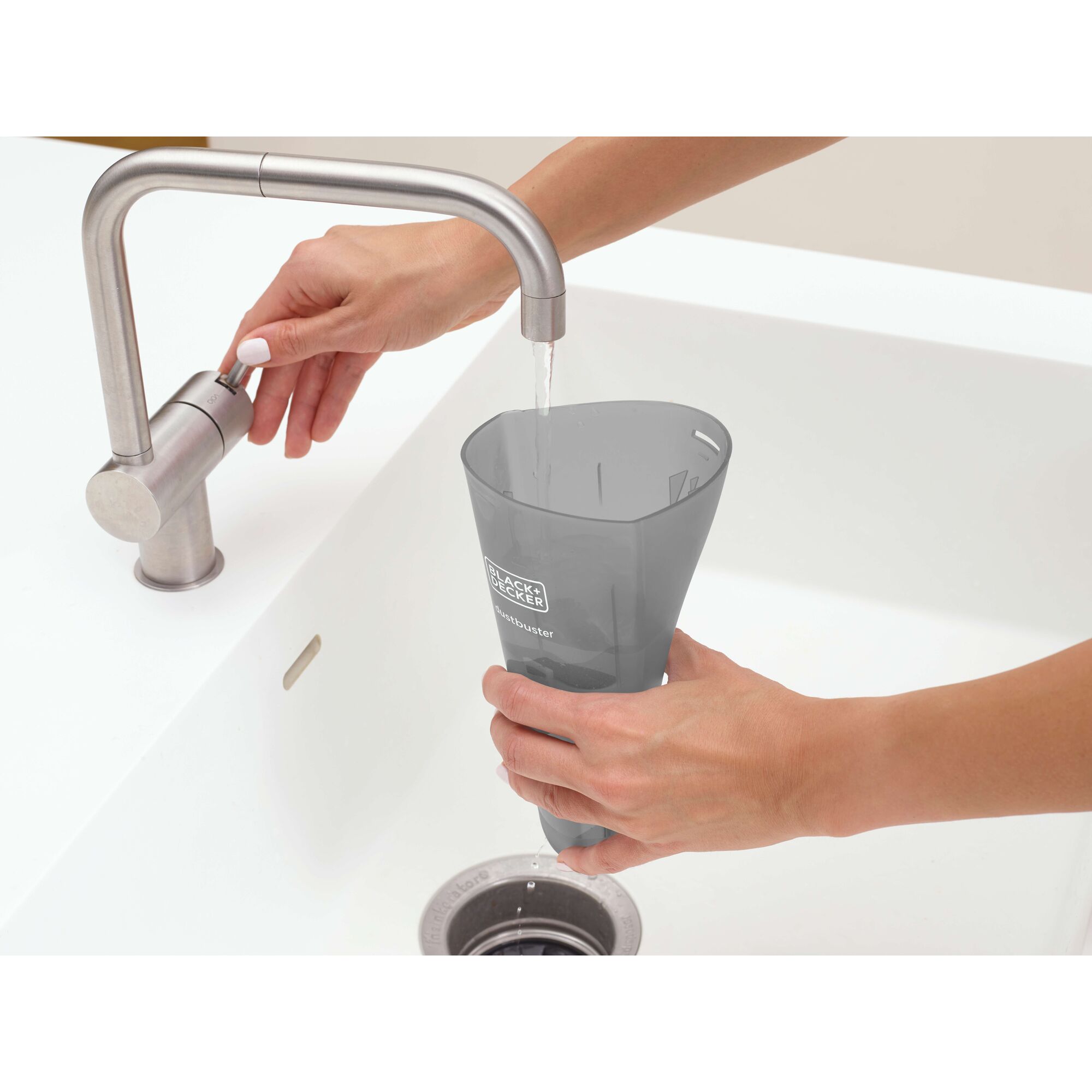 BLACKDECKER NVB115JM-B1 dustbuster container rinsed under faucet in white kitchen sink.