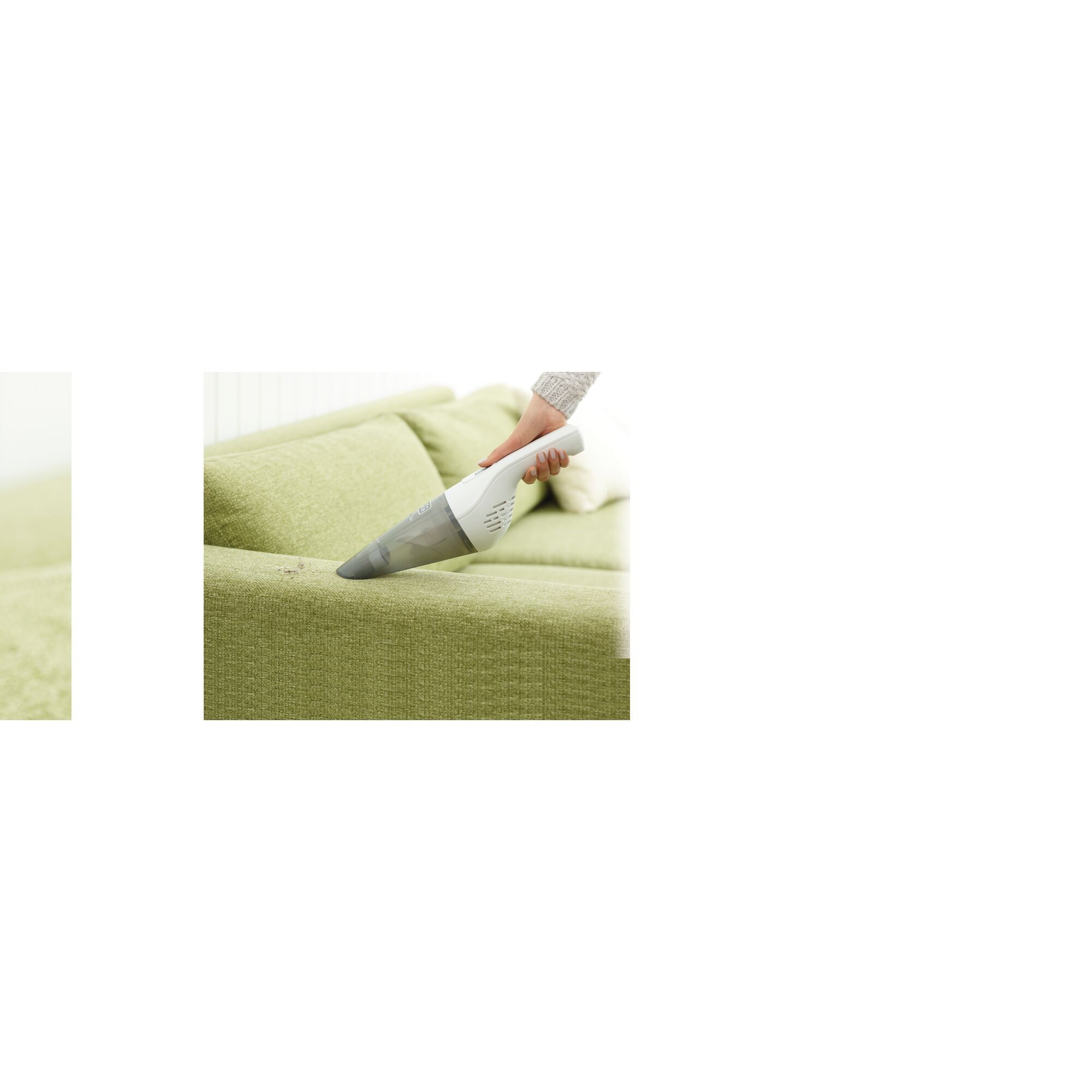 BLACKDECKER NVB115J handheld vacuum cleaning a green sofa, product photography.