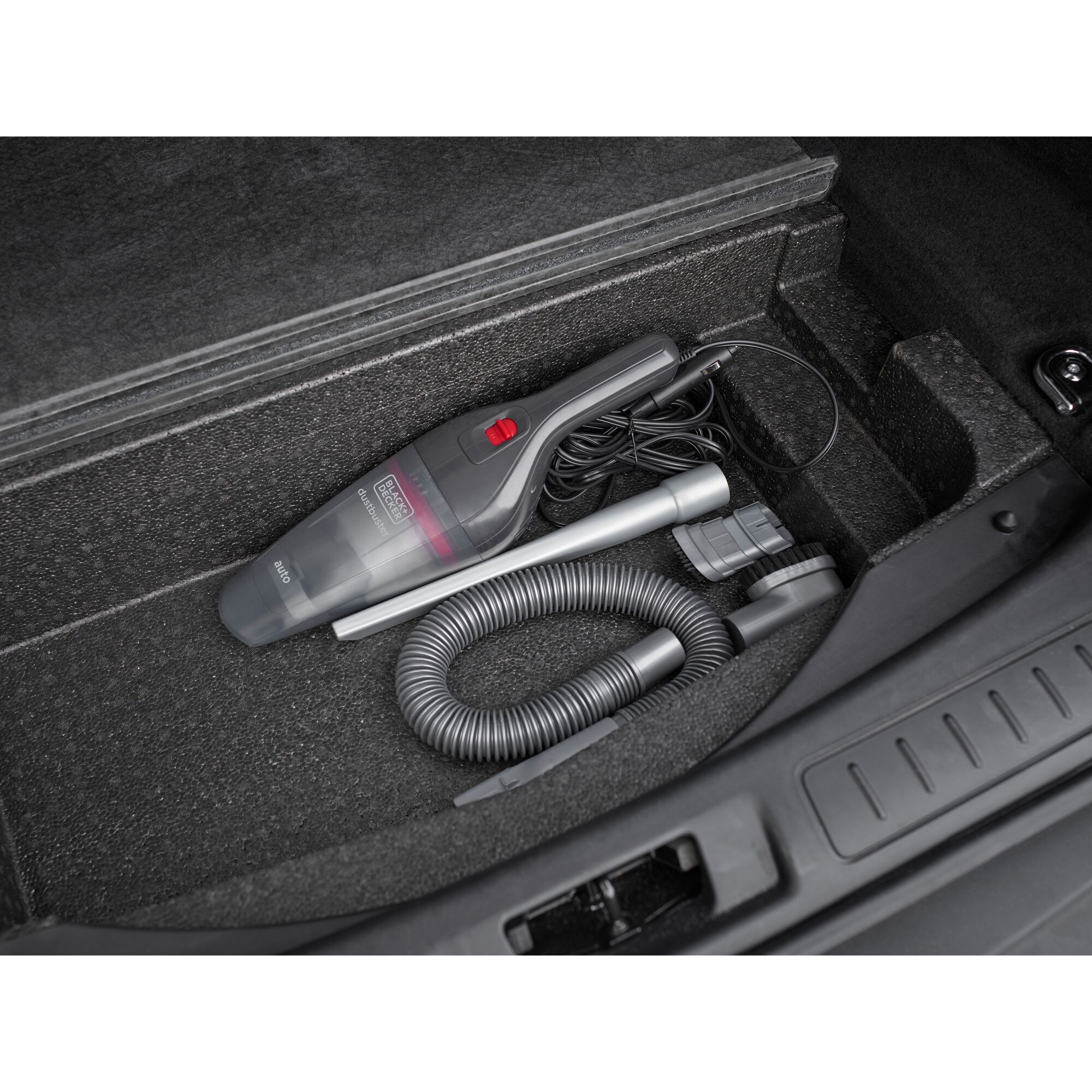 BLACKDECKER NVB12AVA handheld vacuum cleaner with accessories in a car trunk.