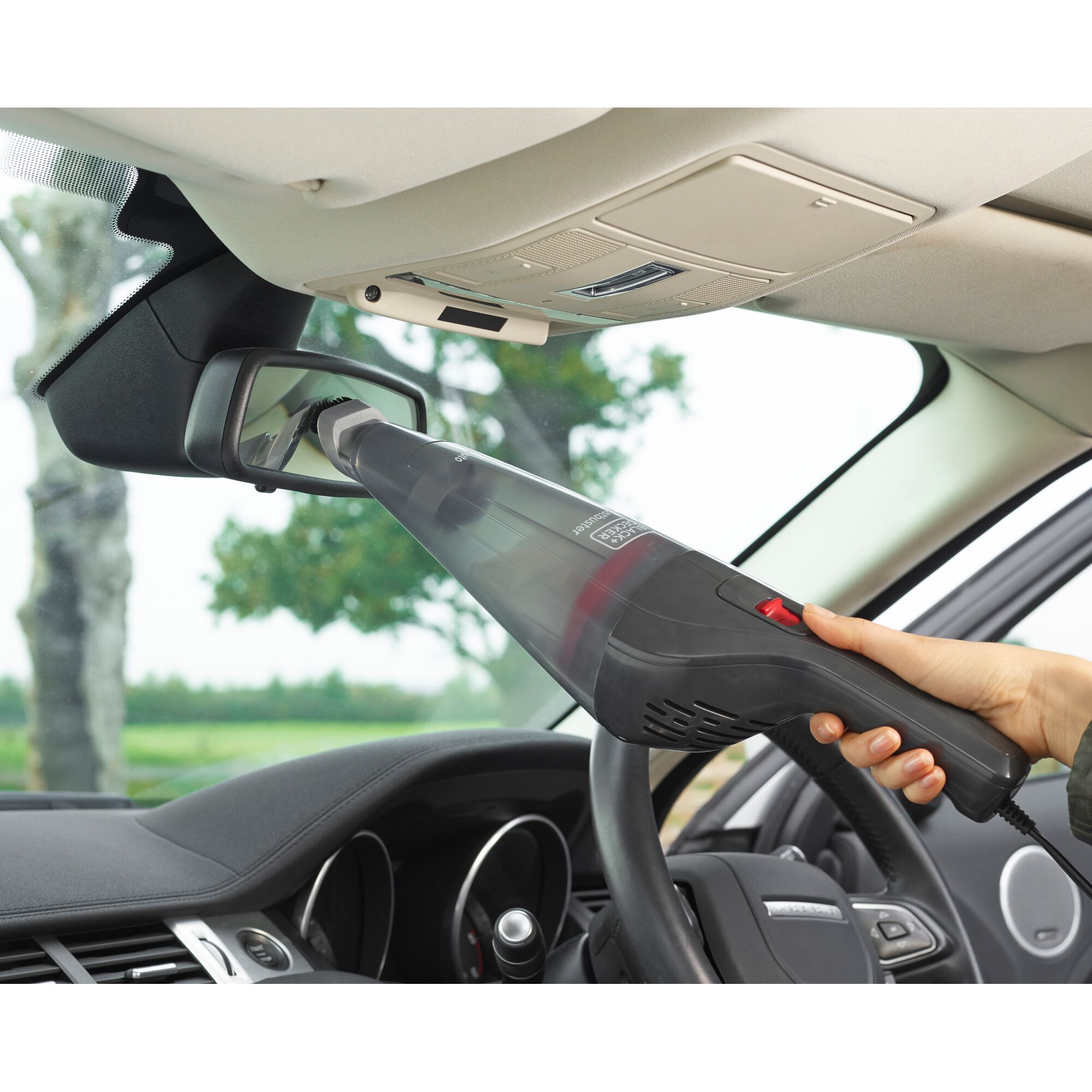 BLACK+DECKER NVB12AVA handheld vacuum cleaning car rearview mirror, close-up inside vehicle.