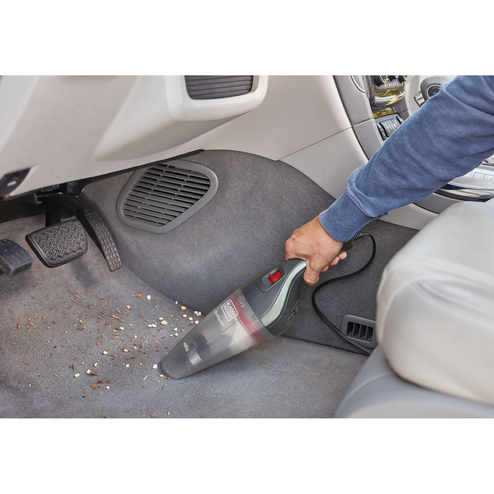 BLACKDECKER NVB12AV hand vacuum cleaning car floor with visible debris in front seat area.