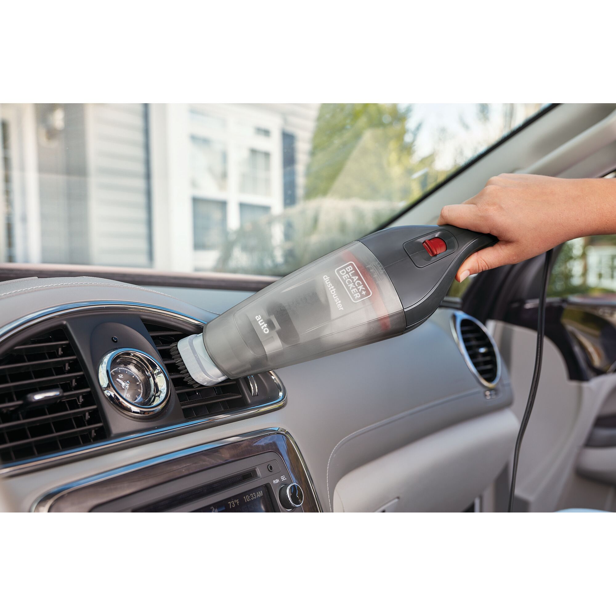 Photo of BLACK+DECKER NVB12AV handheld vacuum cleaning a car air vent, shown in use inside a vehicle.