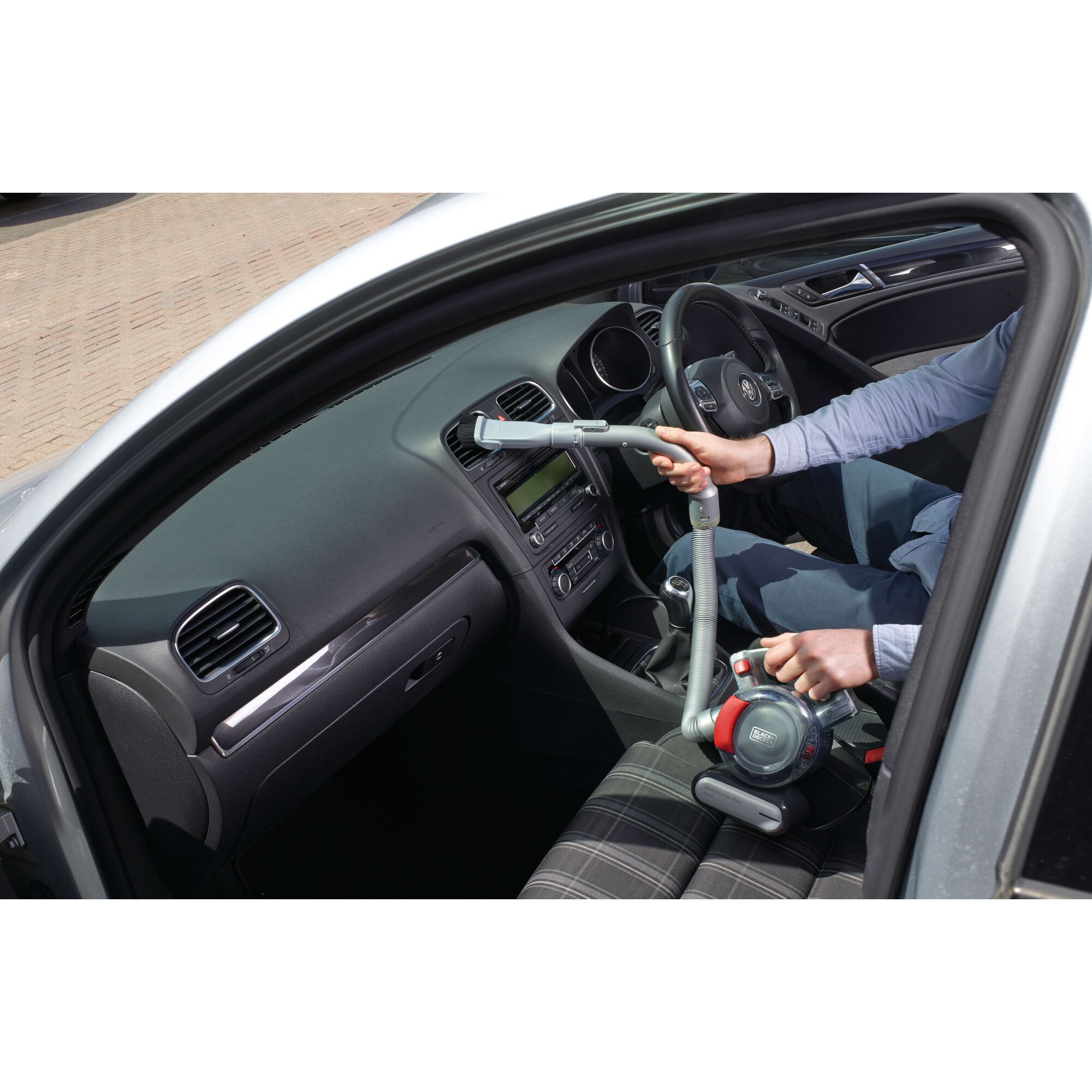 BLACKDECKER PD1200AV handheld car vacuum cleaner used inside vehicle, flexible hose visible.