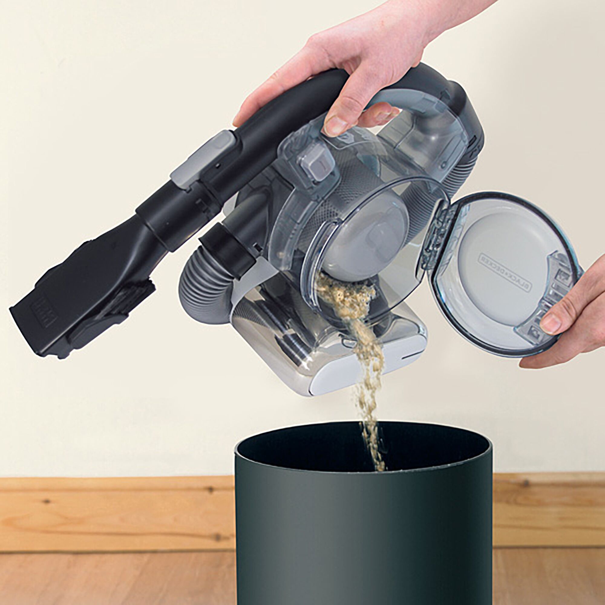 BLACKDECKER PD1810LI handheld vacuum being emptied into a bin, side angle.
