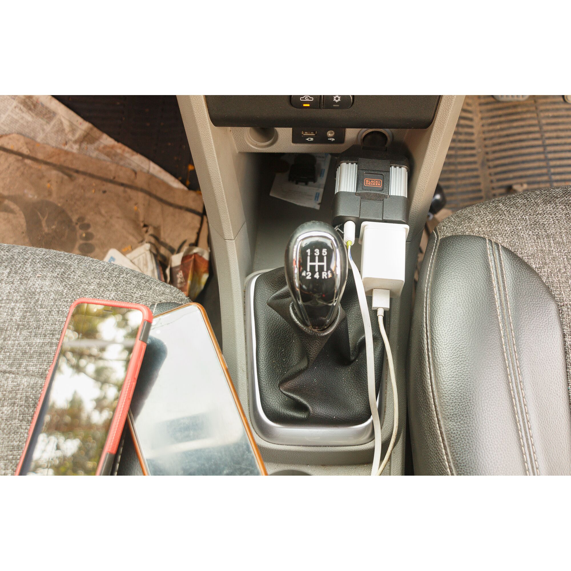 BLACKDECKER PI100LA car power inverter with two USB ports charging devices in car console.