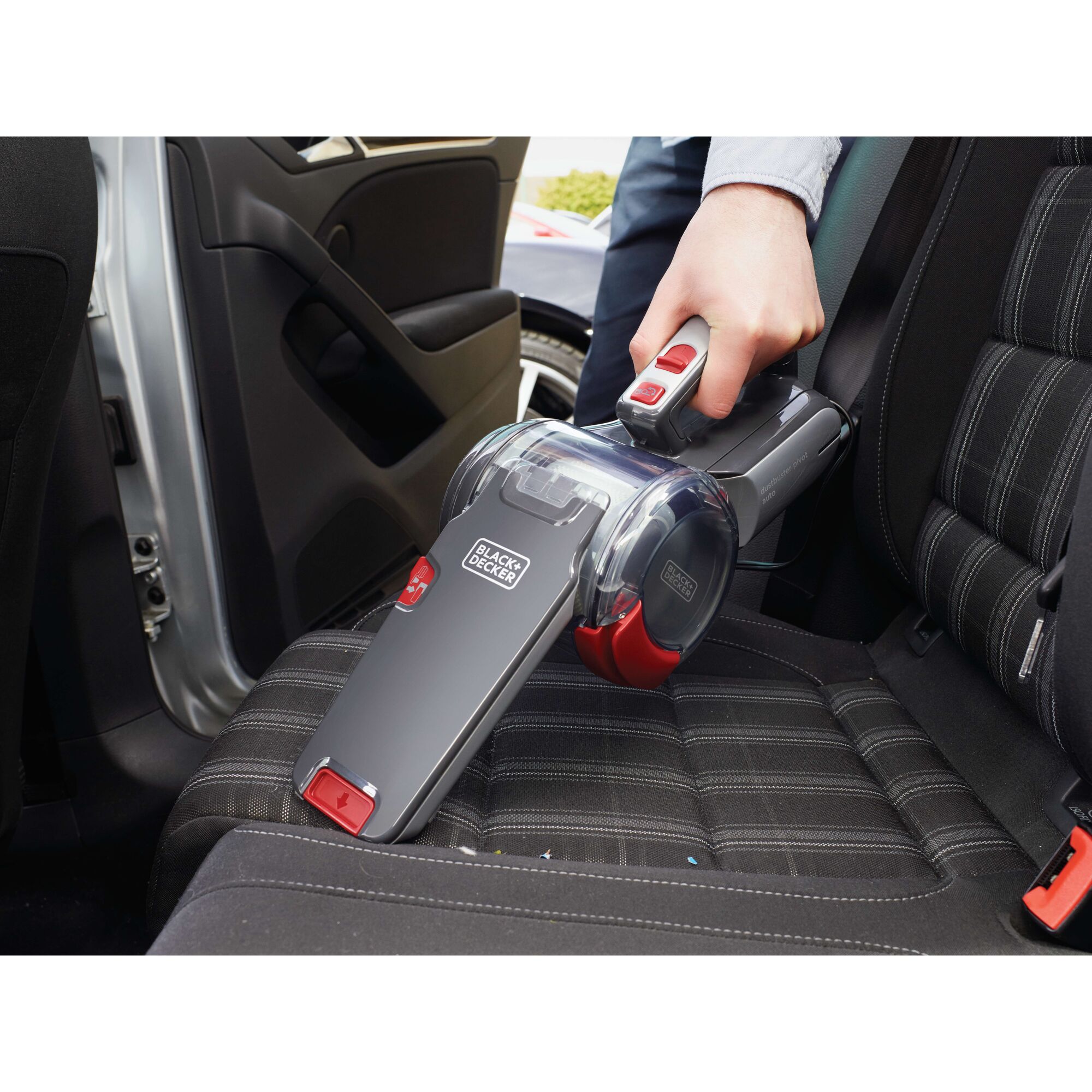 BLACKDECKER PV1200AV handheld vacuum cleaner used on car seat, close-up photo, grey and red design.