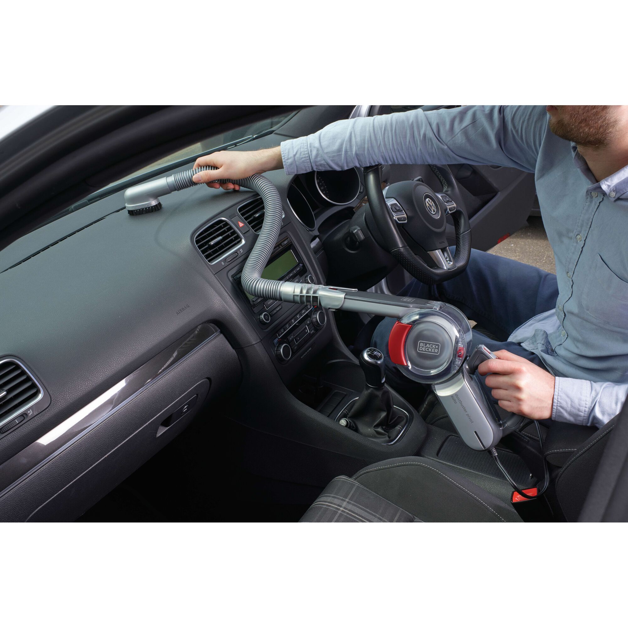 Photo of BLACK+DECKER PV1200AV handheld car vacuum cleaner with hose, cleaning a car dashboard interior.
