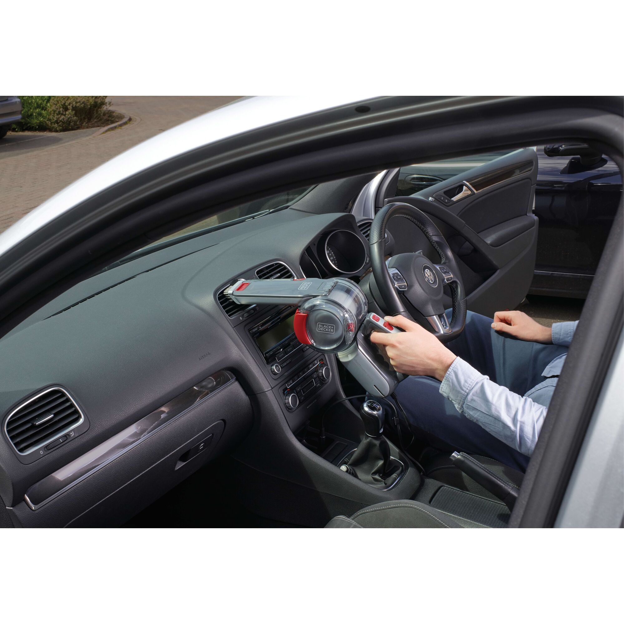 BLACKDECKER PV1200AV handheld vacuum cleaning car dashboard, photography of product in use.