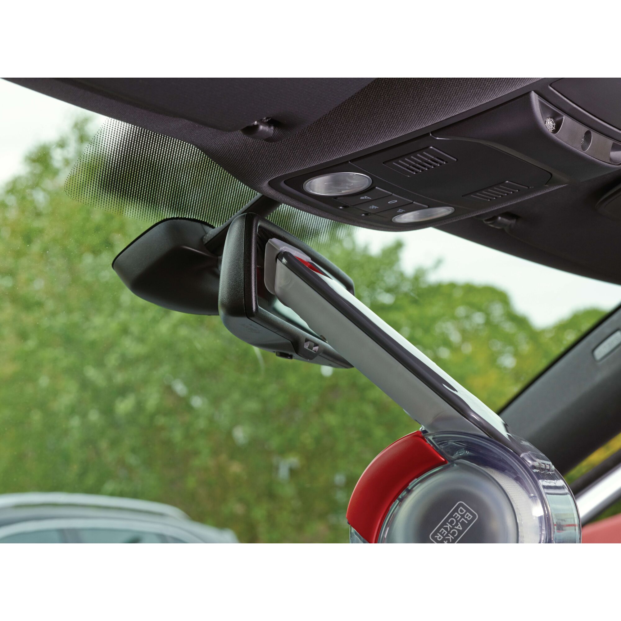 BLACKDECKER PV1200AV handheld car vacuum cleaning around rearview mirror, close-up angle.