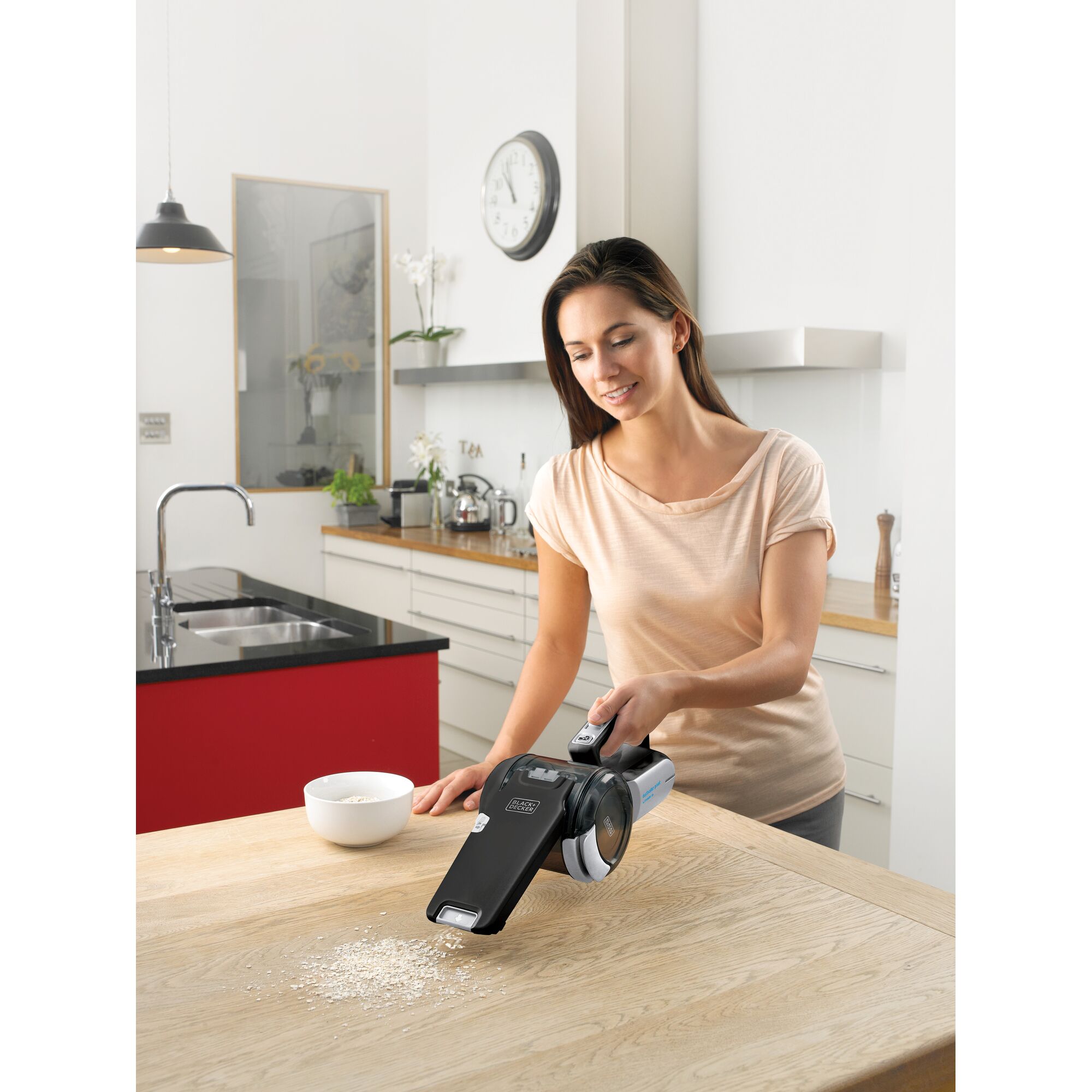 BLACKDECKER PV1820BK handheld vacuum cleaner being used on kitchen table to clean spilled oats.