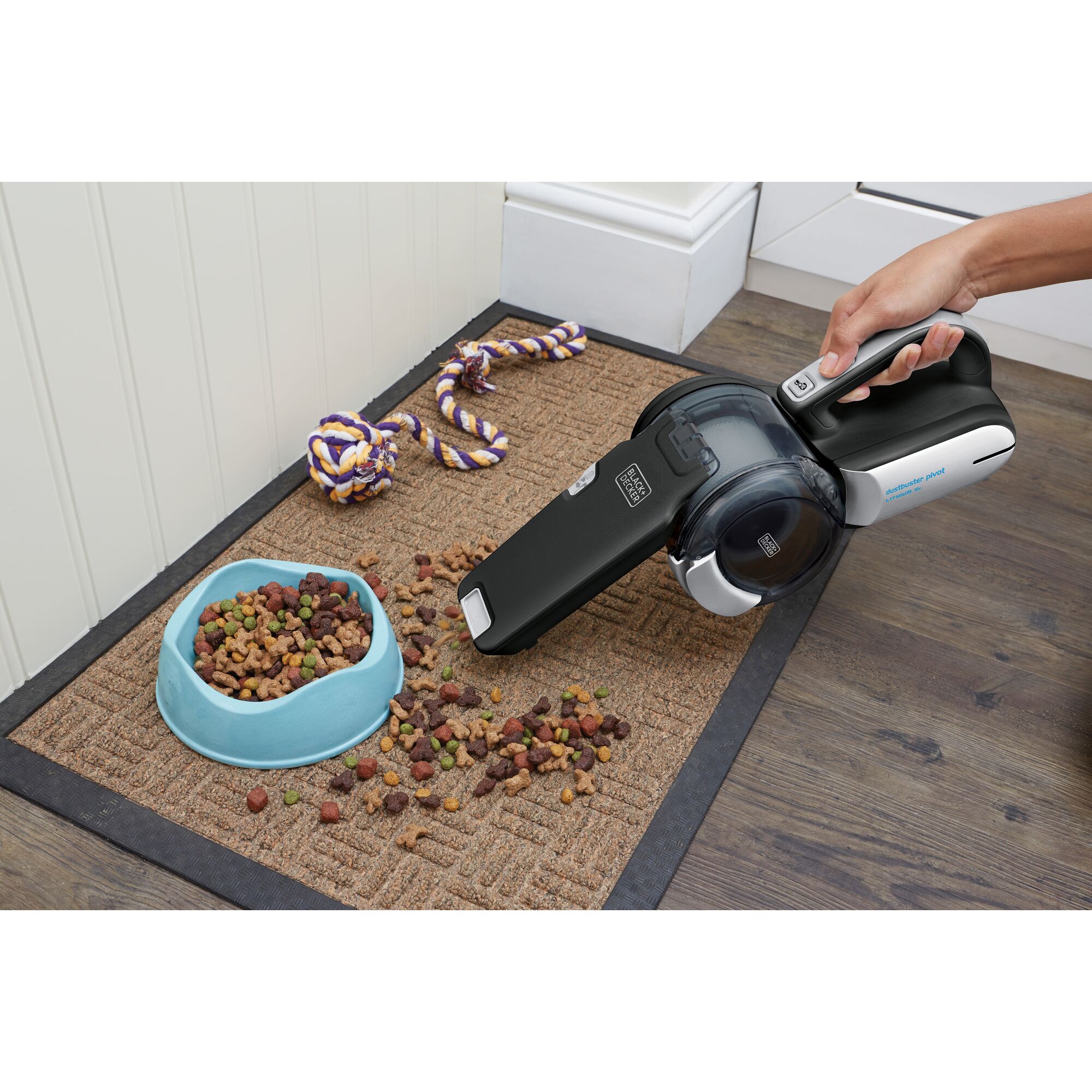 BLACKDECKER PV1820BK handheld vacuum cleaning pet food on mat near blue bowl, close-up.