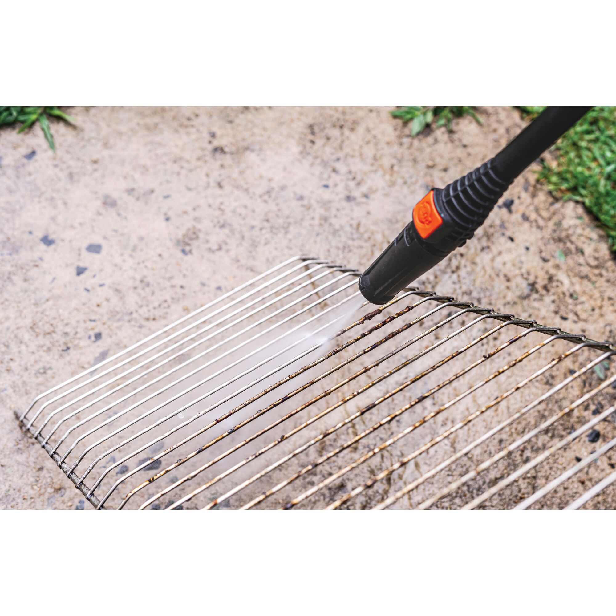 BLACKDECKER PW1450TD pressure washer cleaning metal grill rack outdoors.