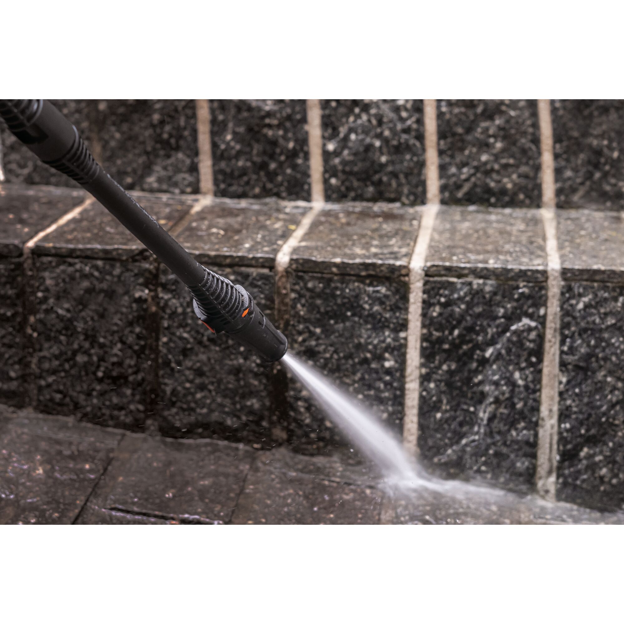 BLACKDECKER PW1450TD pressure washer spraying water on dark stone steps.