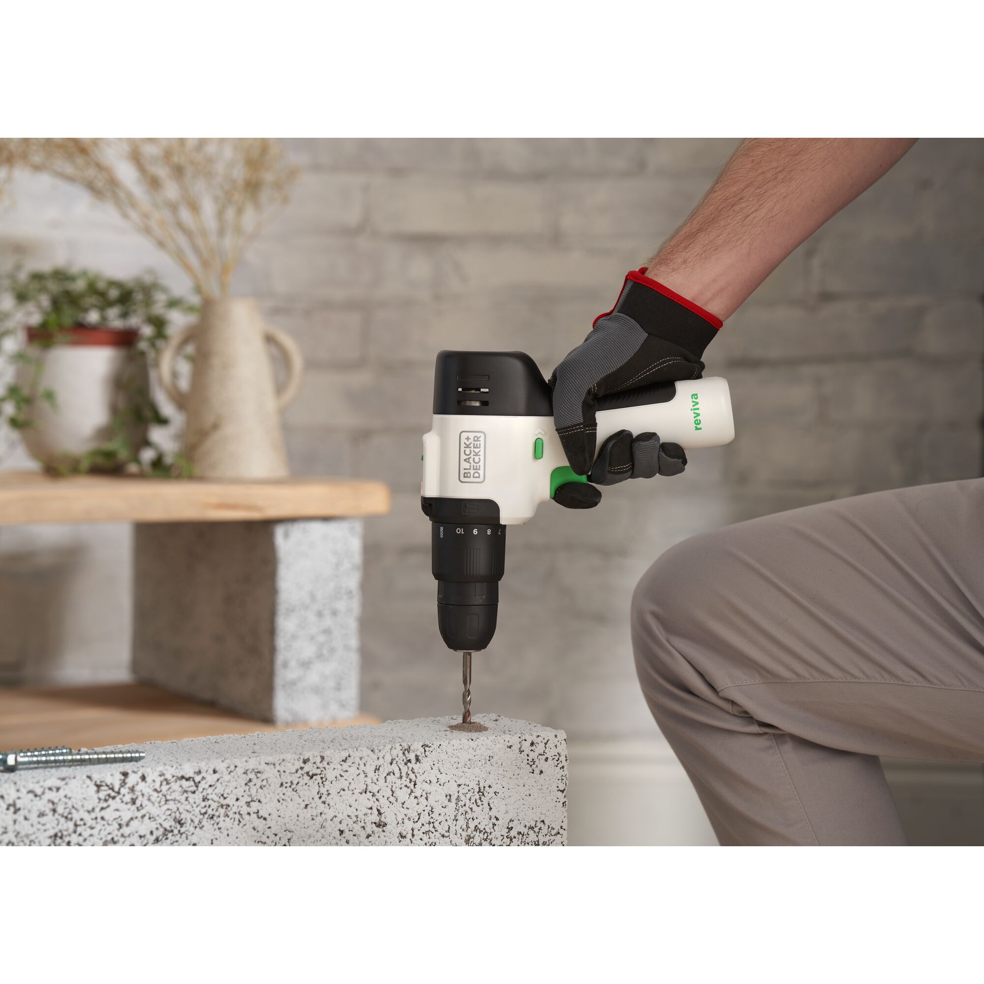 BLACKDECKER REVHD12C cordless drill in use, drilling into concrete, indoor setting.