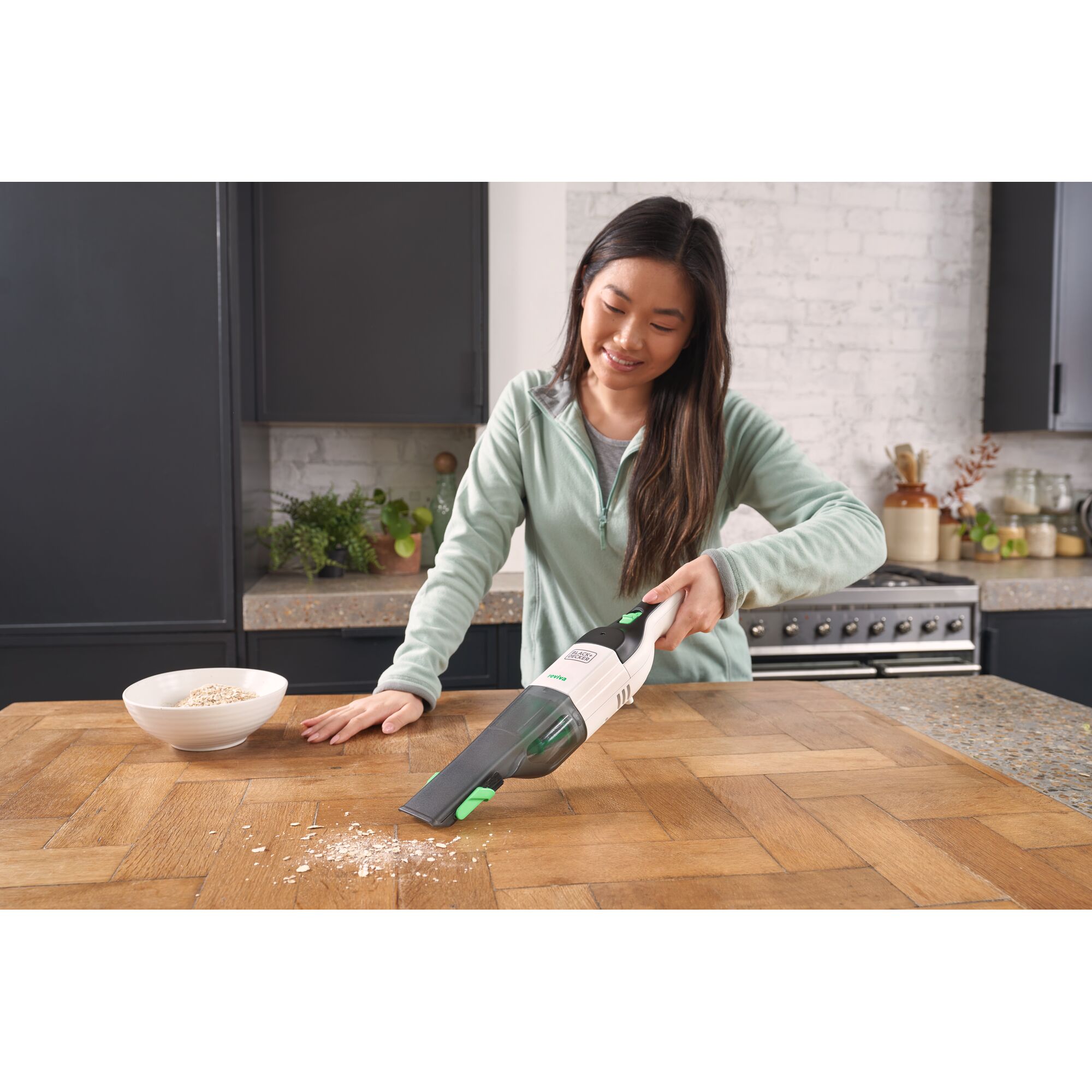 BLACKDECKER REVHV8C handheld vacuum cleaning crumbs on kitchen table, photography of product in use.
