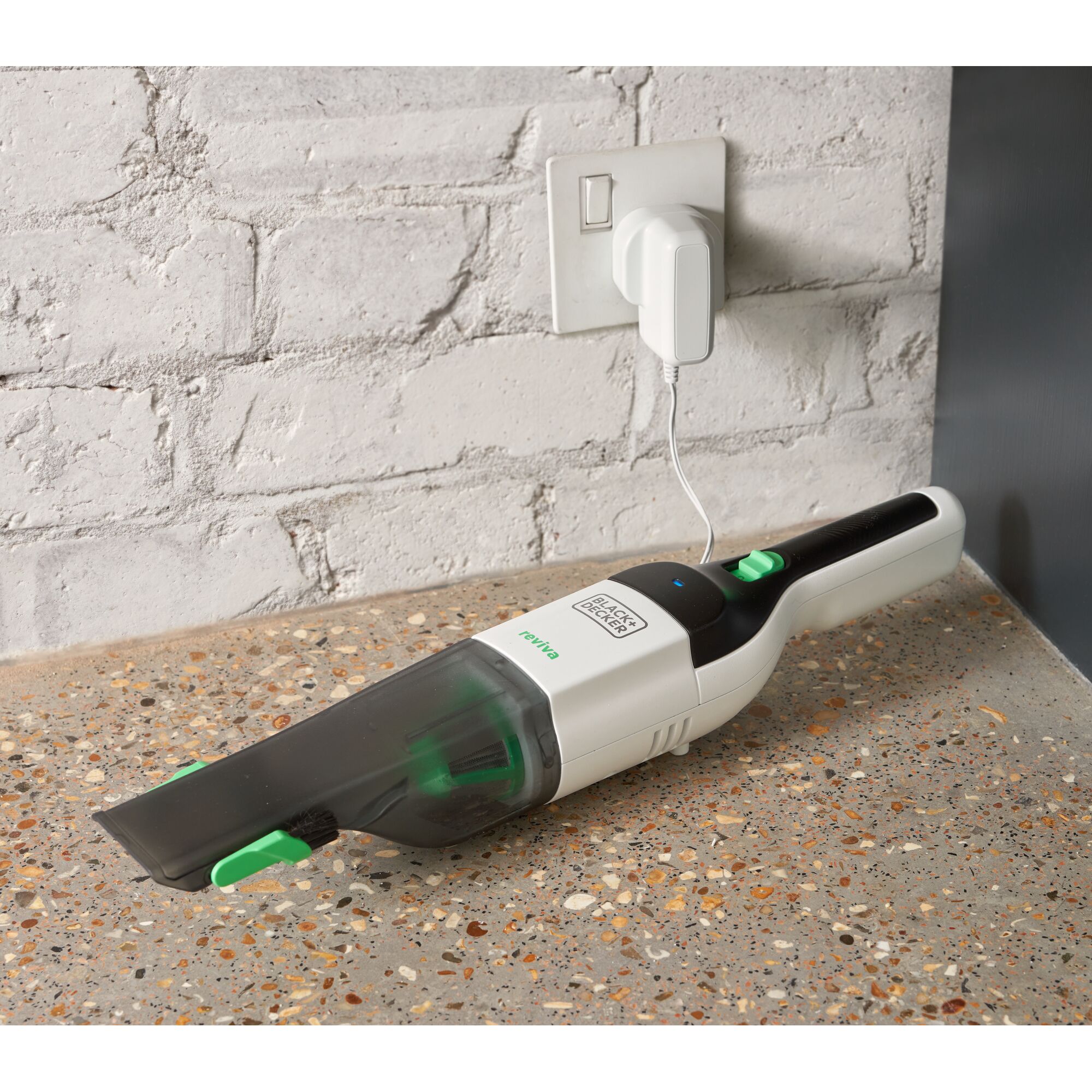 BLACKDECKER REVHV8C handheld vacuum being charged on a speckled countertop, angled side view.