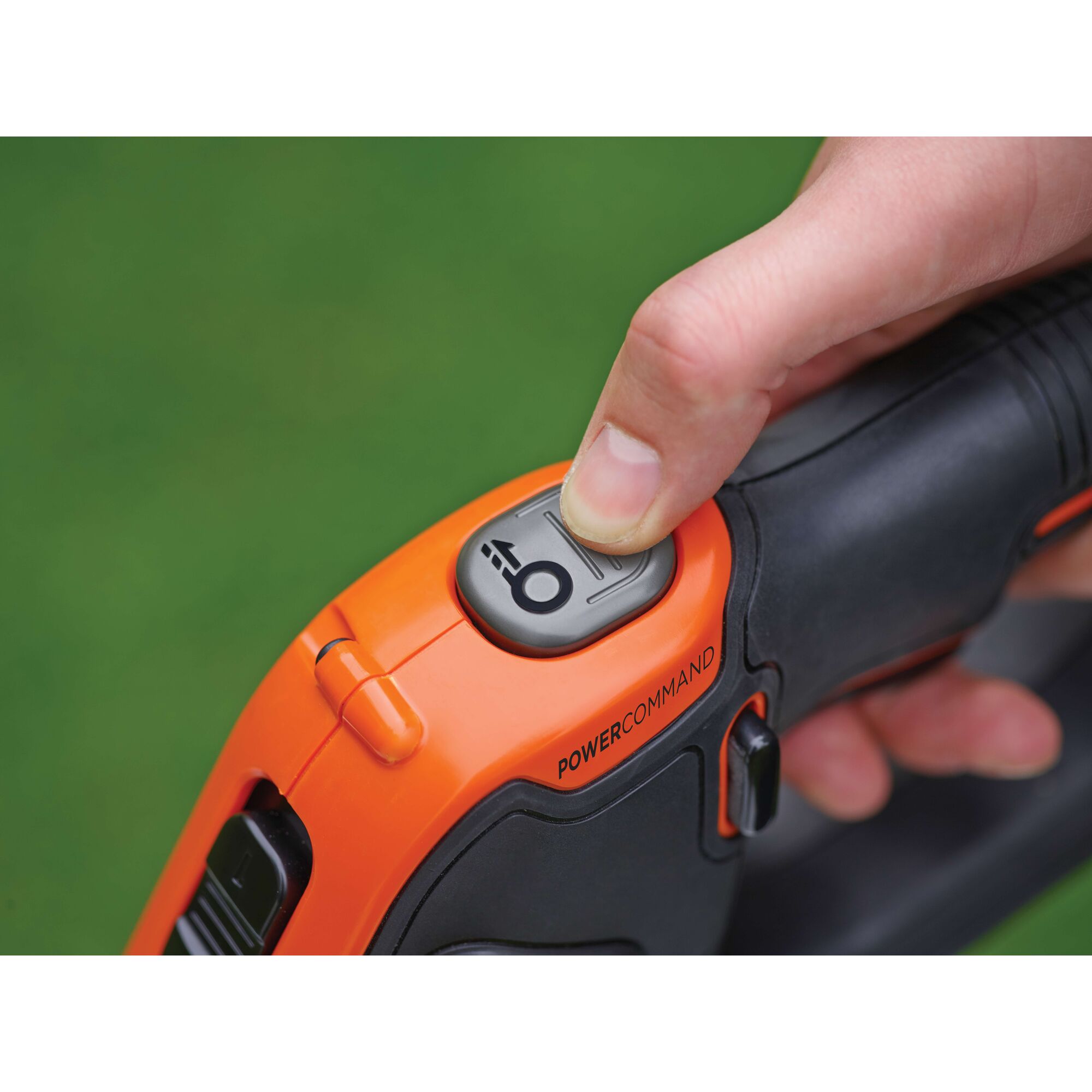 Close-up photo of BLACKDECKER STC1820EPC trimmer handle with finger pressing POWERCOMMAND button.