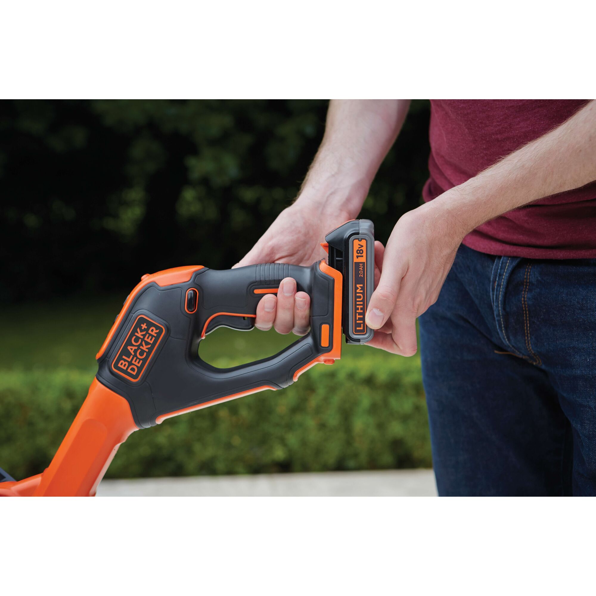 BLACKDECKER STC1820EPC cordless tool handle with person inserting 18V lithium battery outdoors.