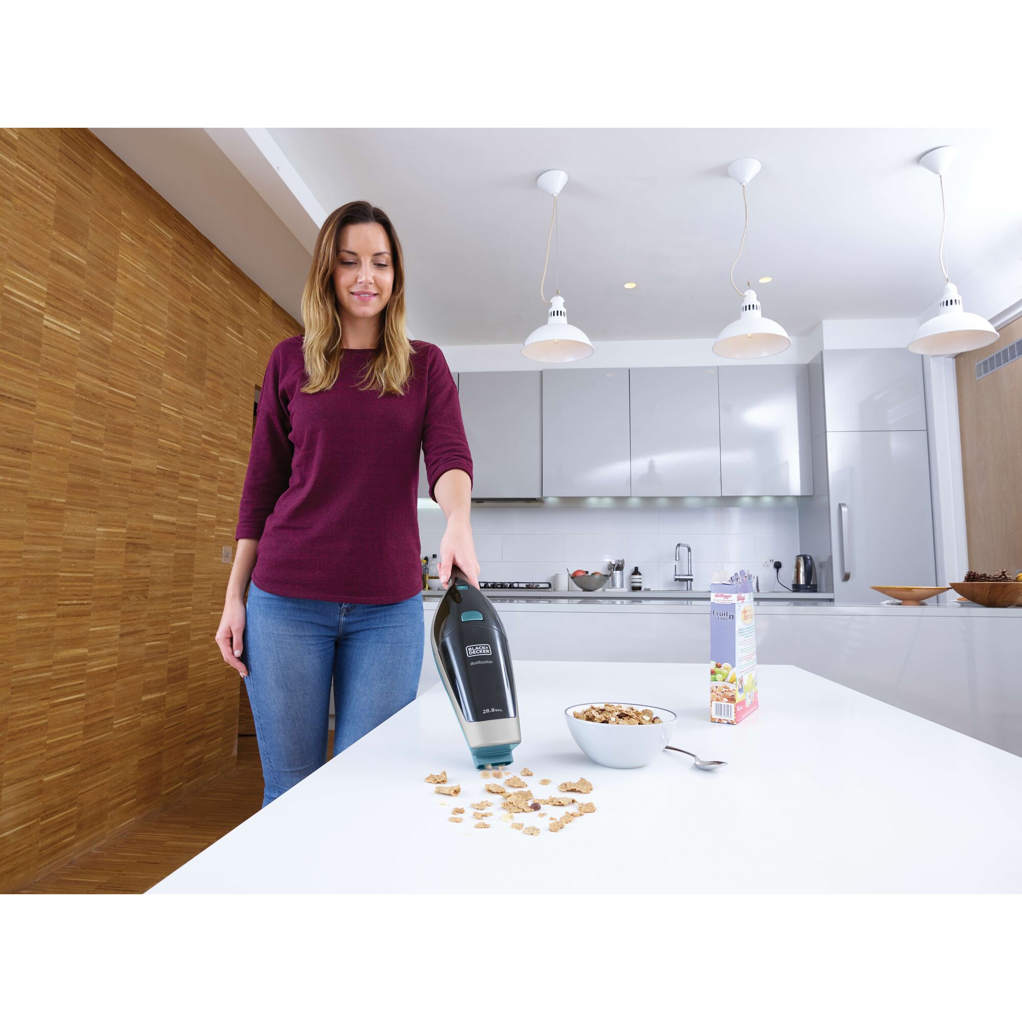 BLACKDECKER SVA420B handheld vacuum cleaning cereal crumbs on kitchen table near a bowl and cereal box.