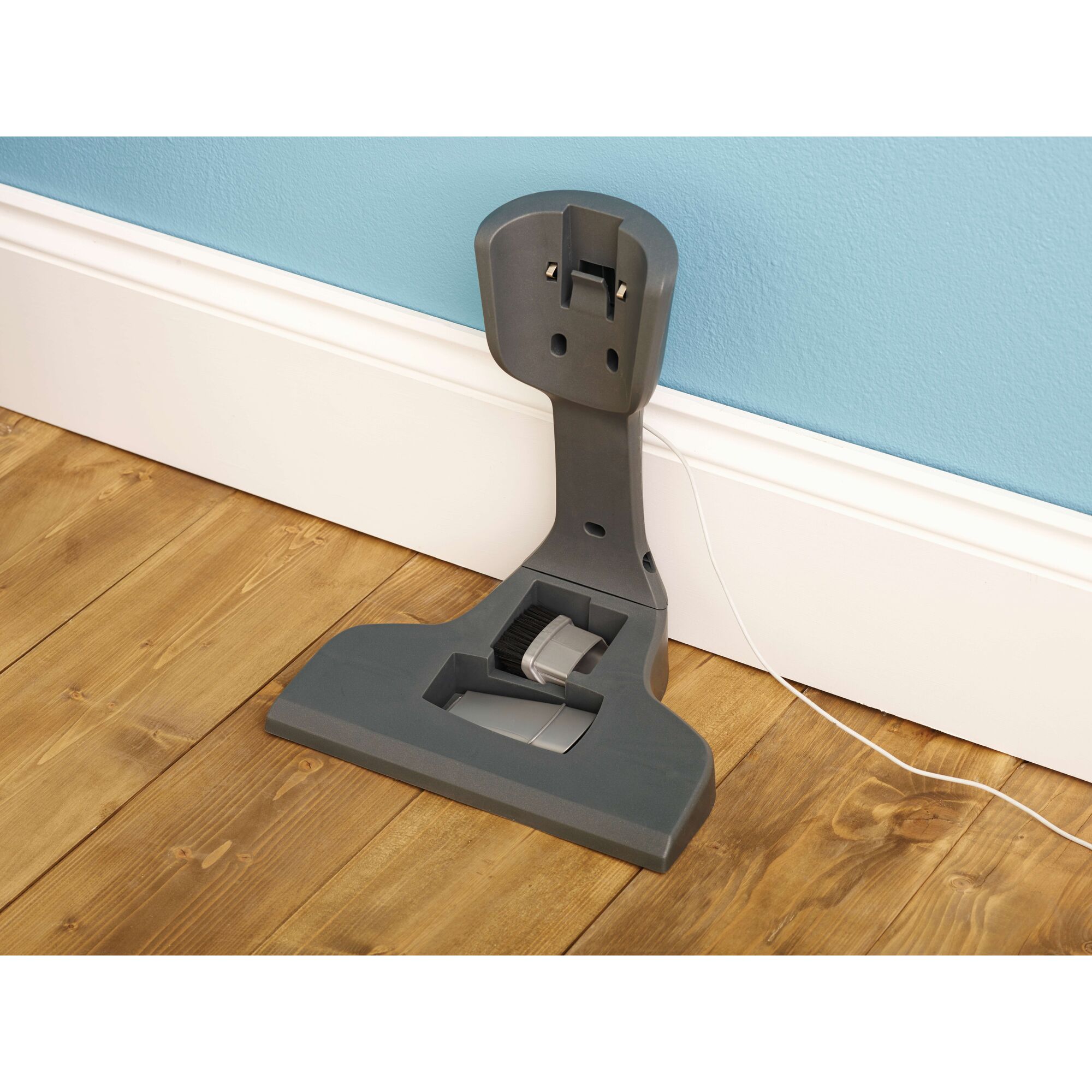 BLACKDECKER SVA420B floor-mounted vacuum charging station against blue wall.