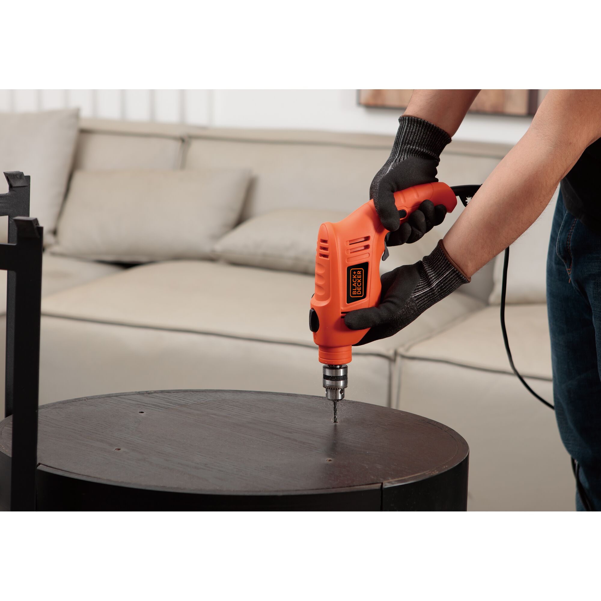 Photo of BLACKDECKER TB555 electric drill being used to drill into a wooden surface indoors.