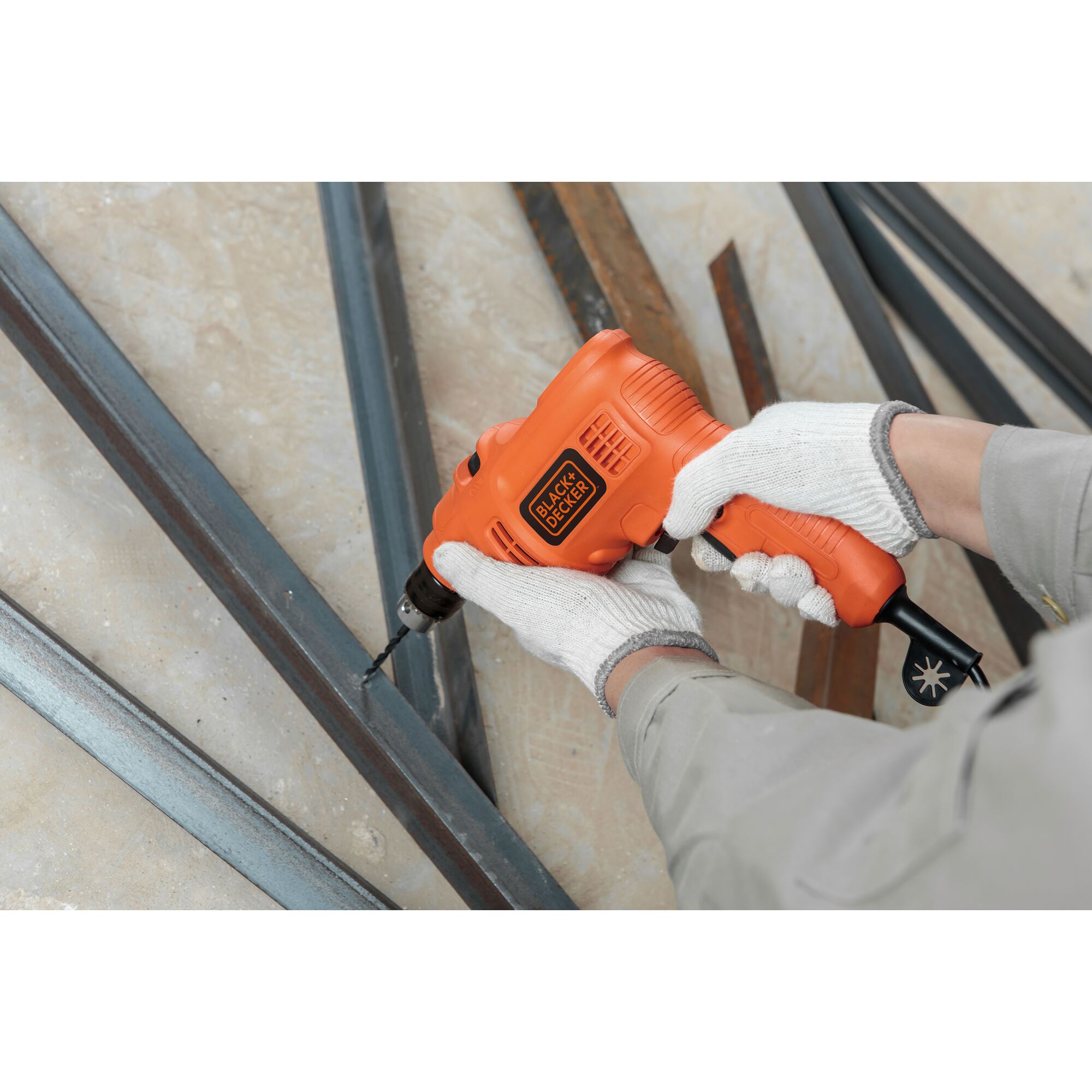 BLACK+DECKER TP555KPR orange electric drill used with gloves to drill into metal bars.
