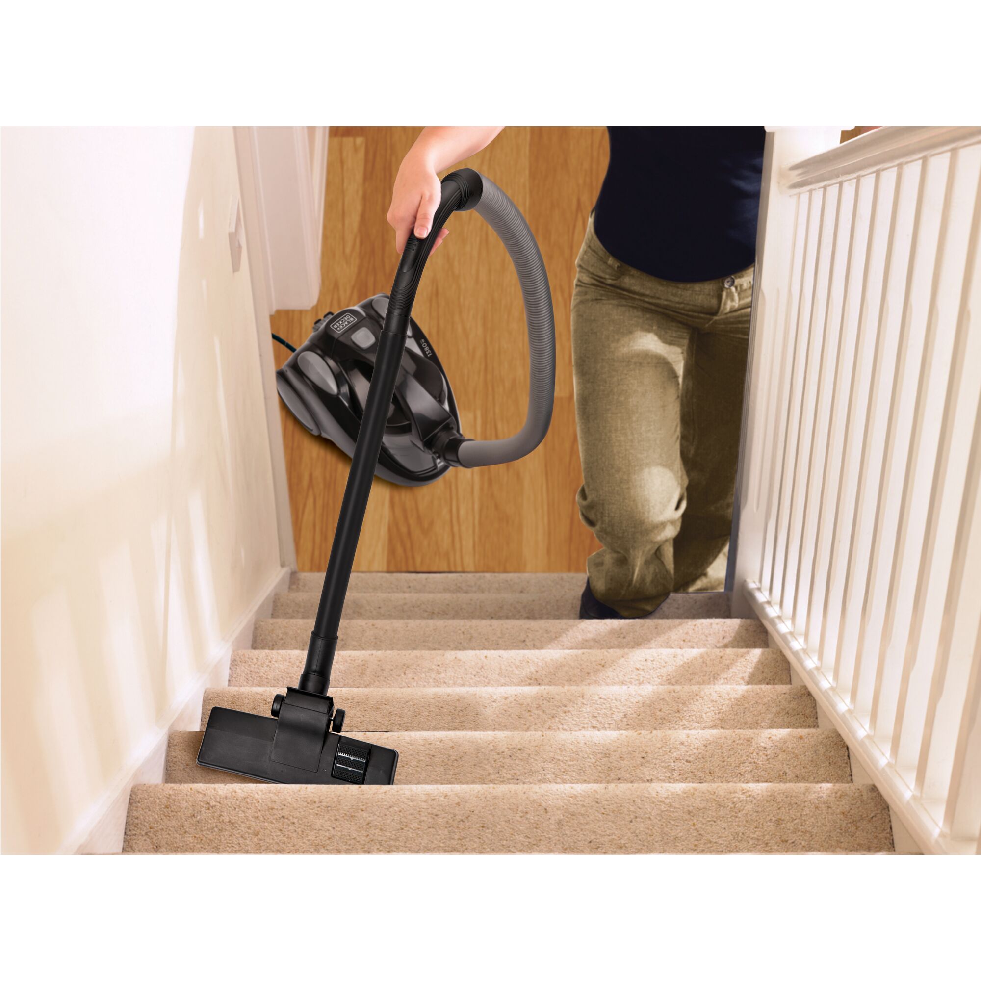 BLACKDECKER VM1450 vacuum cleaner used to clean carpeted stairs, held by a person.