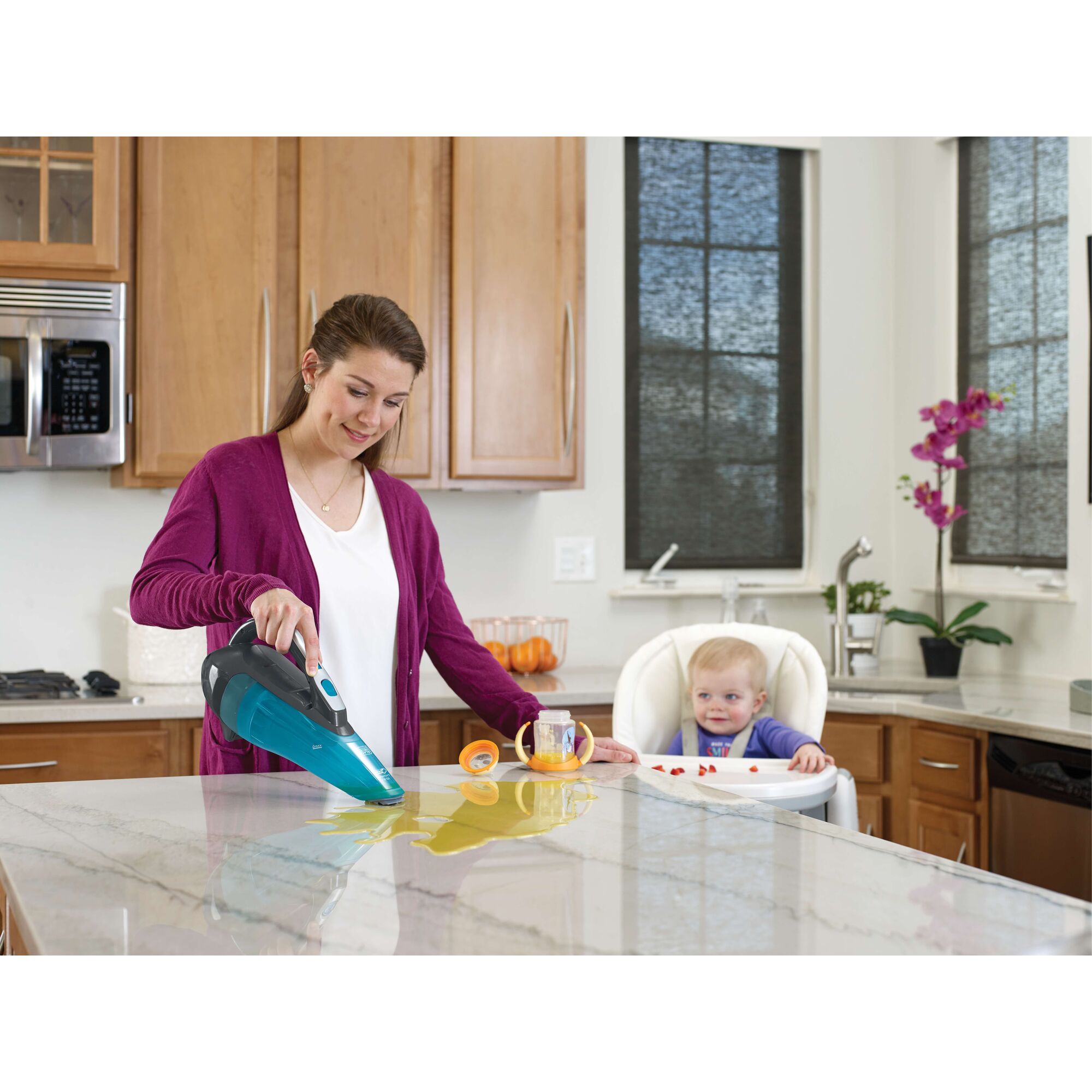 BLACKDECKER WDA320B handheld vacuum cleaning liquid spill on kitchen counter with baby in high chair.