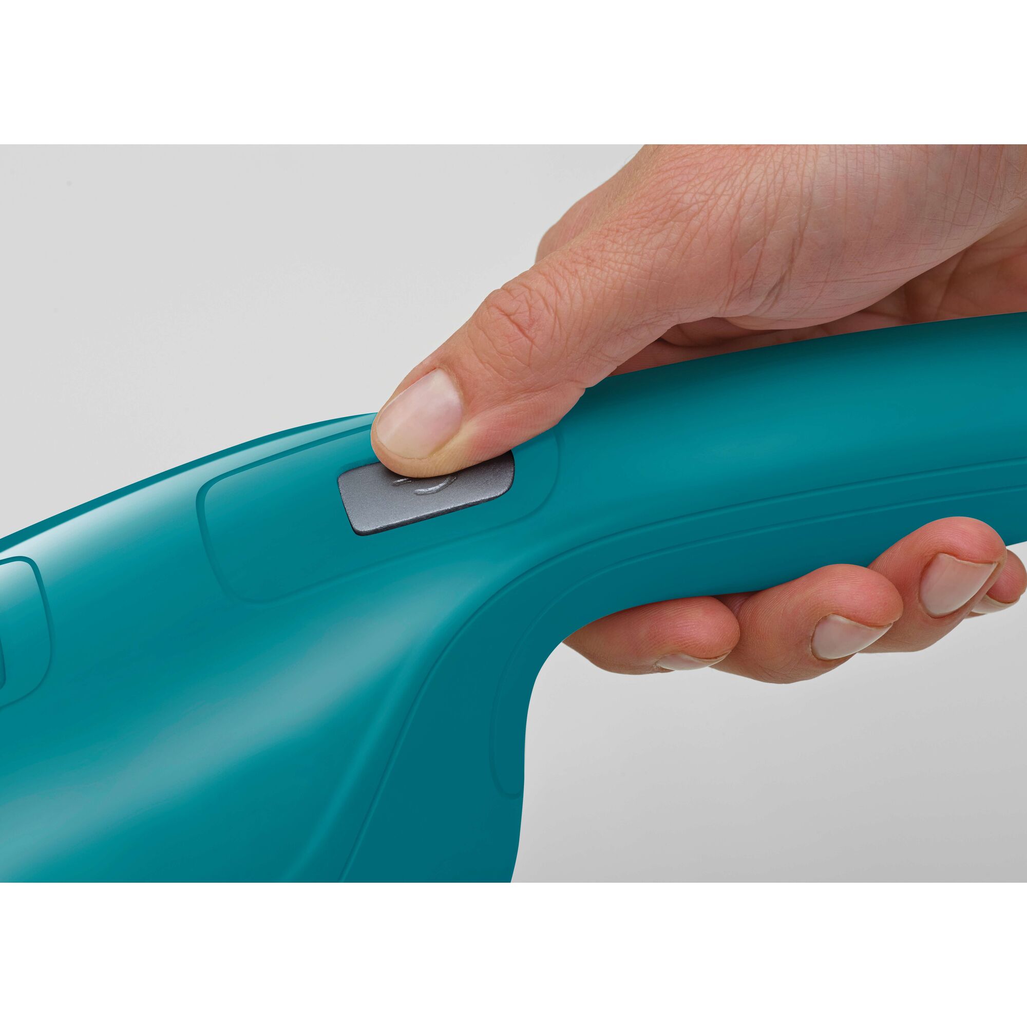 Close-up of a hand pressing the power button on a teal handheld device, which appears to be a Black+Decker product.