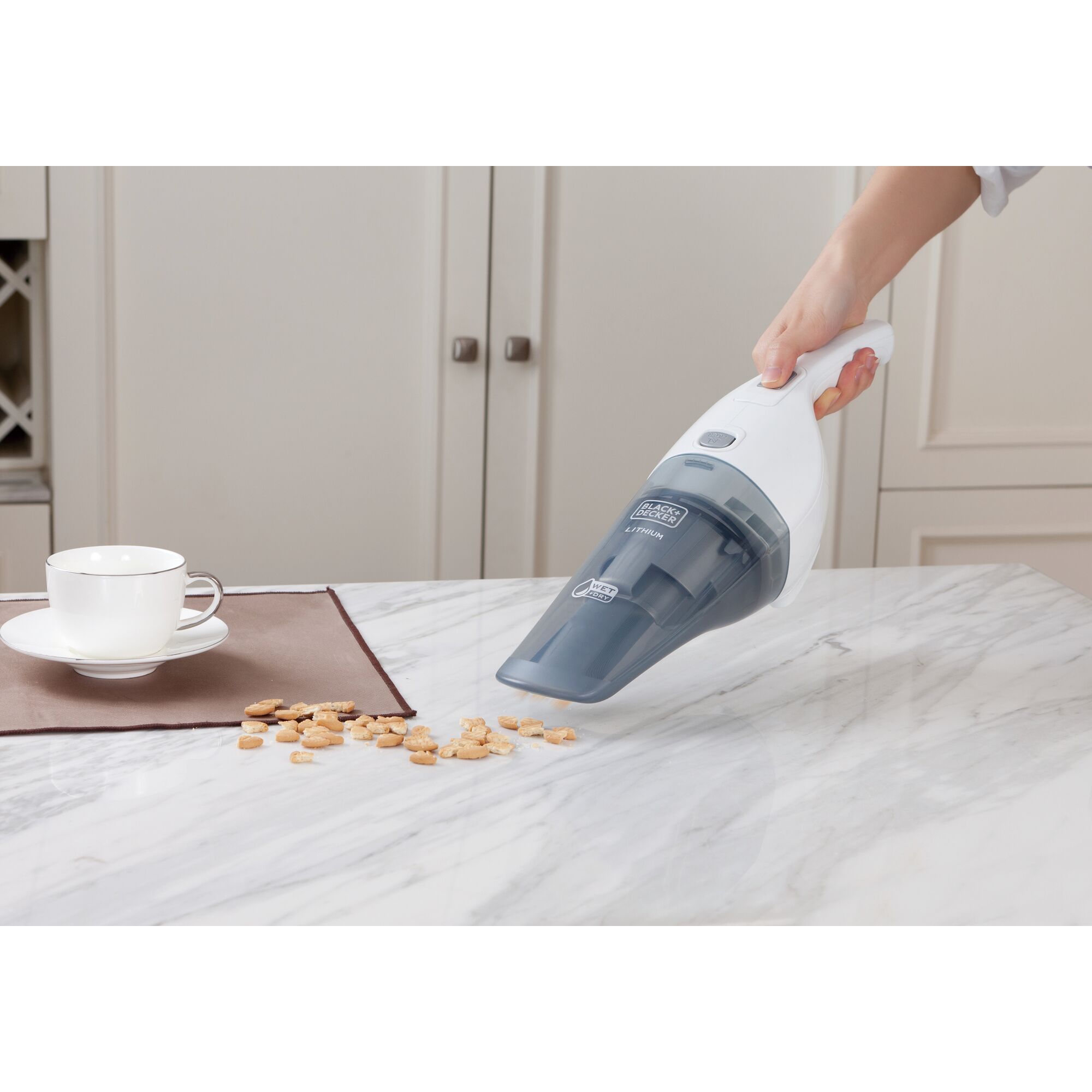 BLACKDECKER WDB115W handheld vacuum cleaner cleaning crumbs on a kitchen counter.