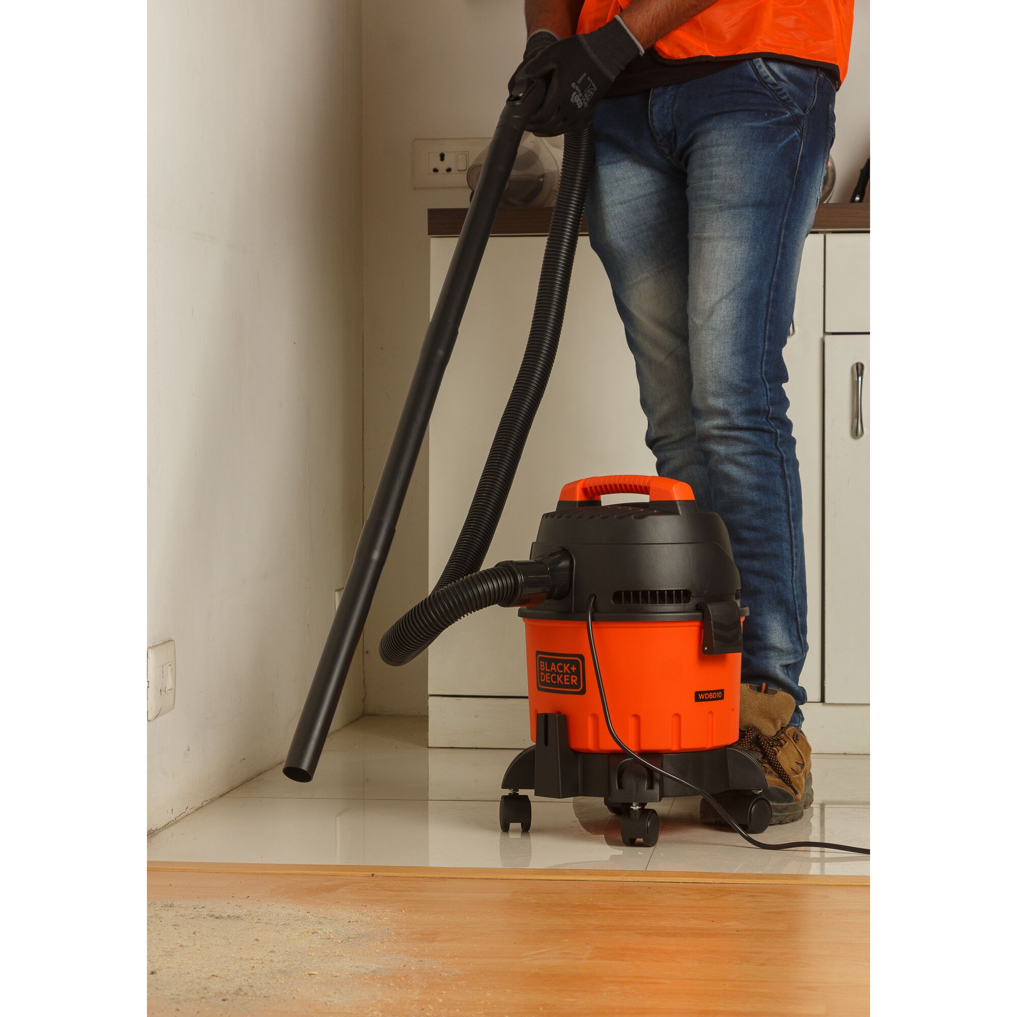 BLACKDECKER WDBD10 wet and dry vacuum cleaner in use on tiled floor, orange and black design.