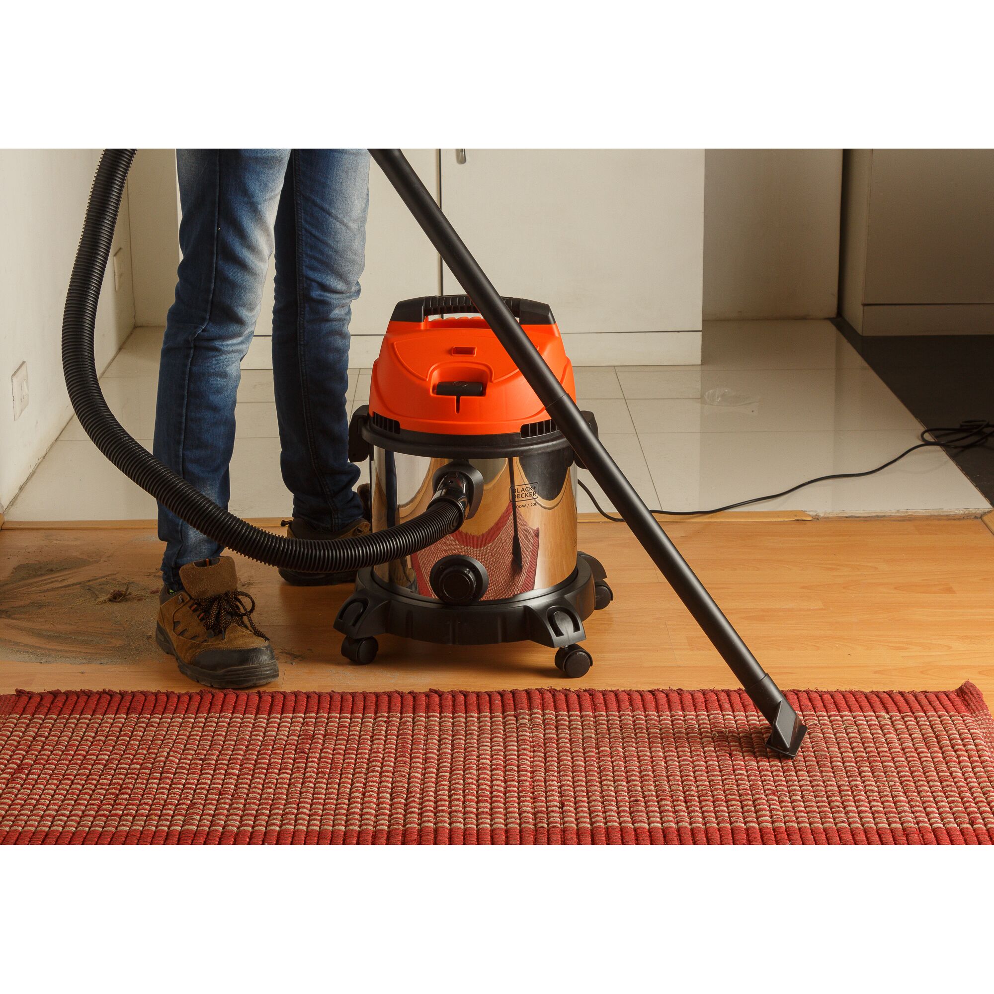 BLACKDECKER WDBDS20 wet and dry vacuum cleaner with orange top cleaning a carpet indoors.