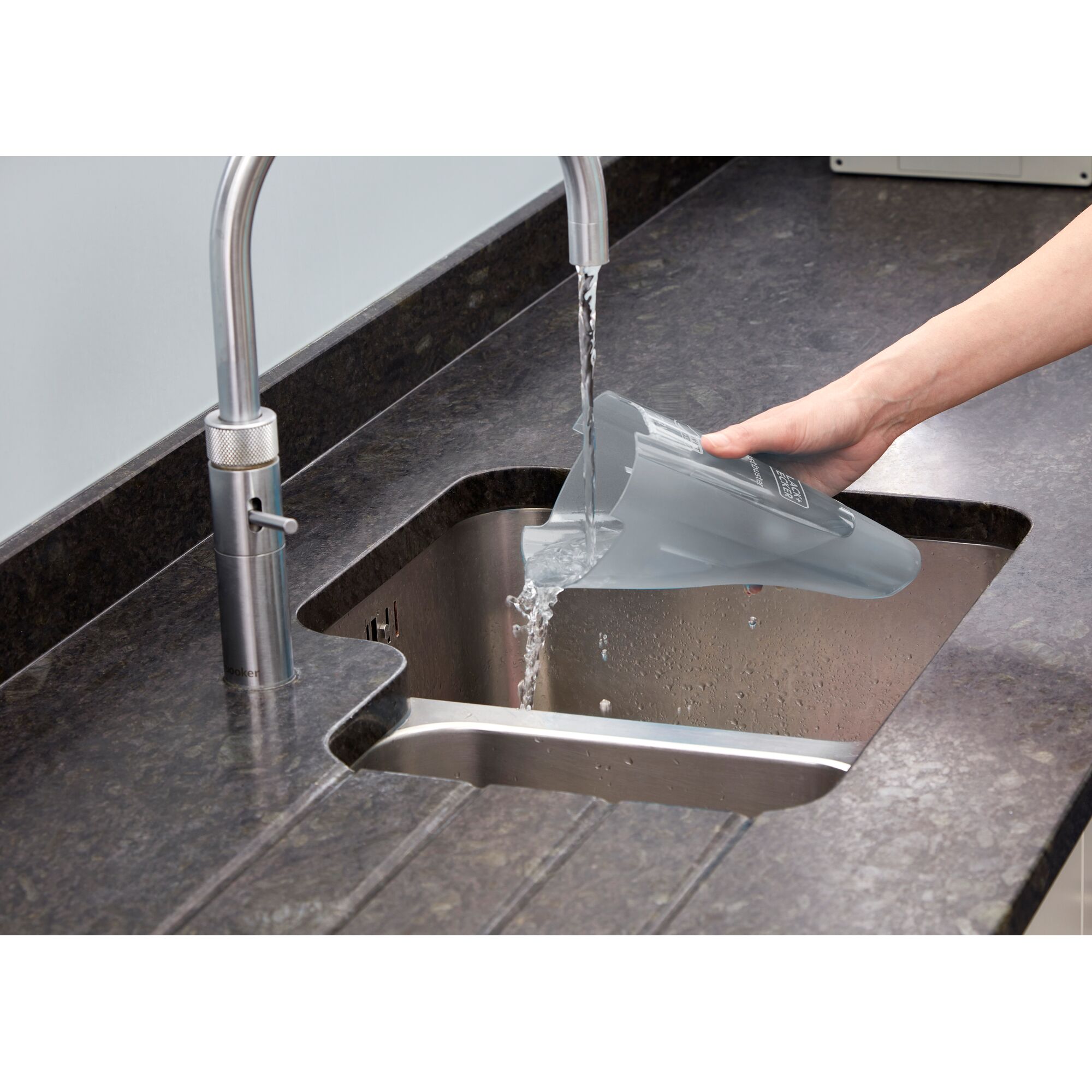 BLACK+DECKER WDC215G handheld vacuum dust container being emptied into a kitchen sink.