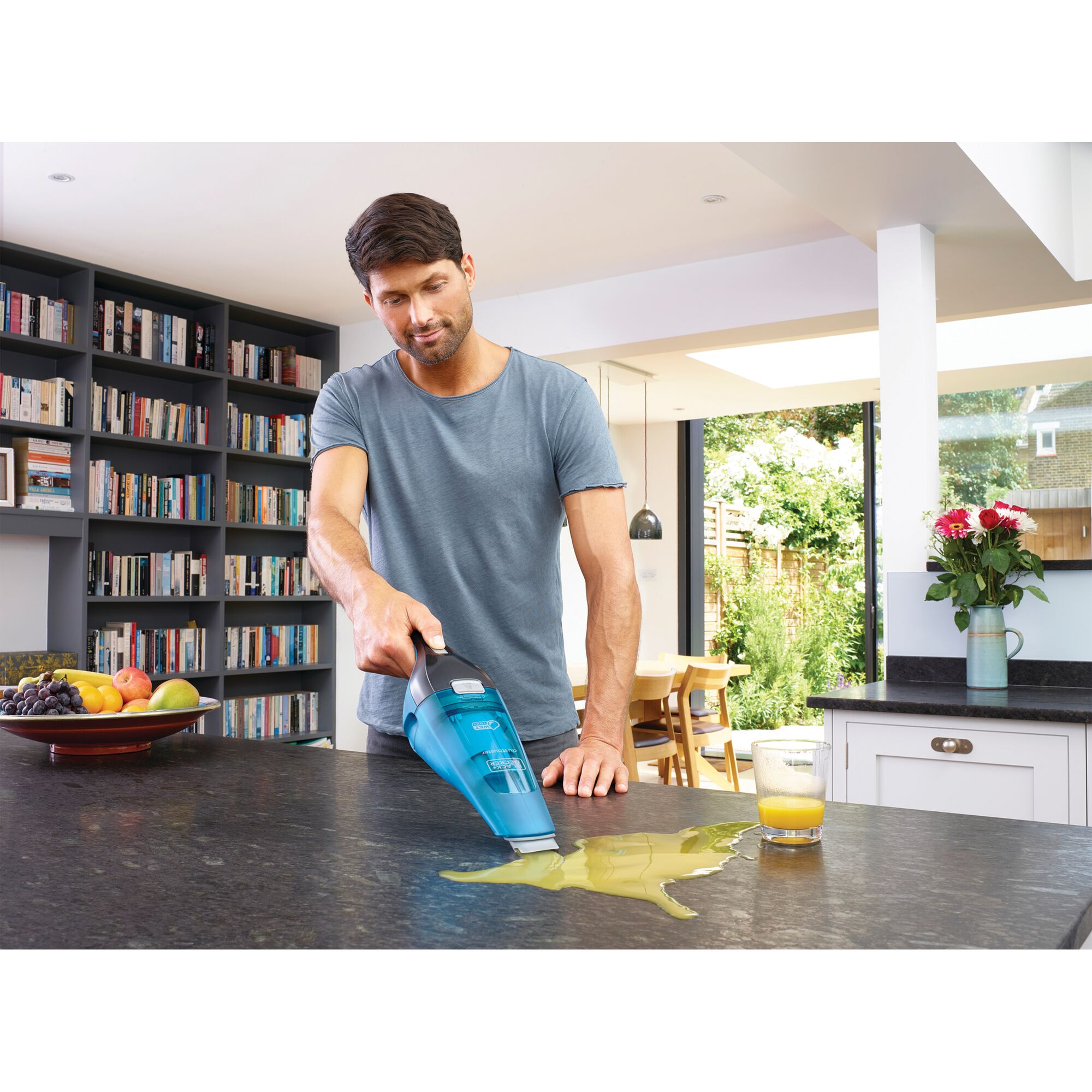 BLACKDECKER WDC215WB handheld vacuum cleaning spilled juice on a kitchen countertop.