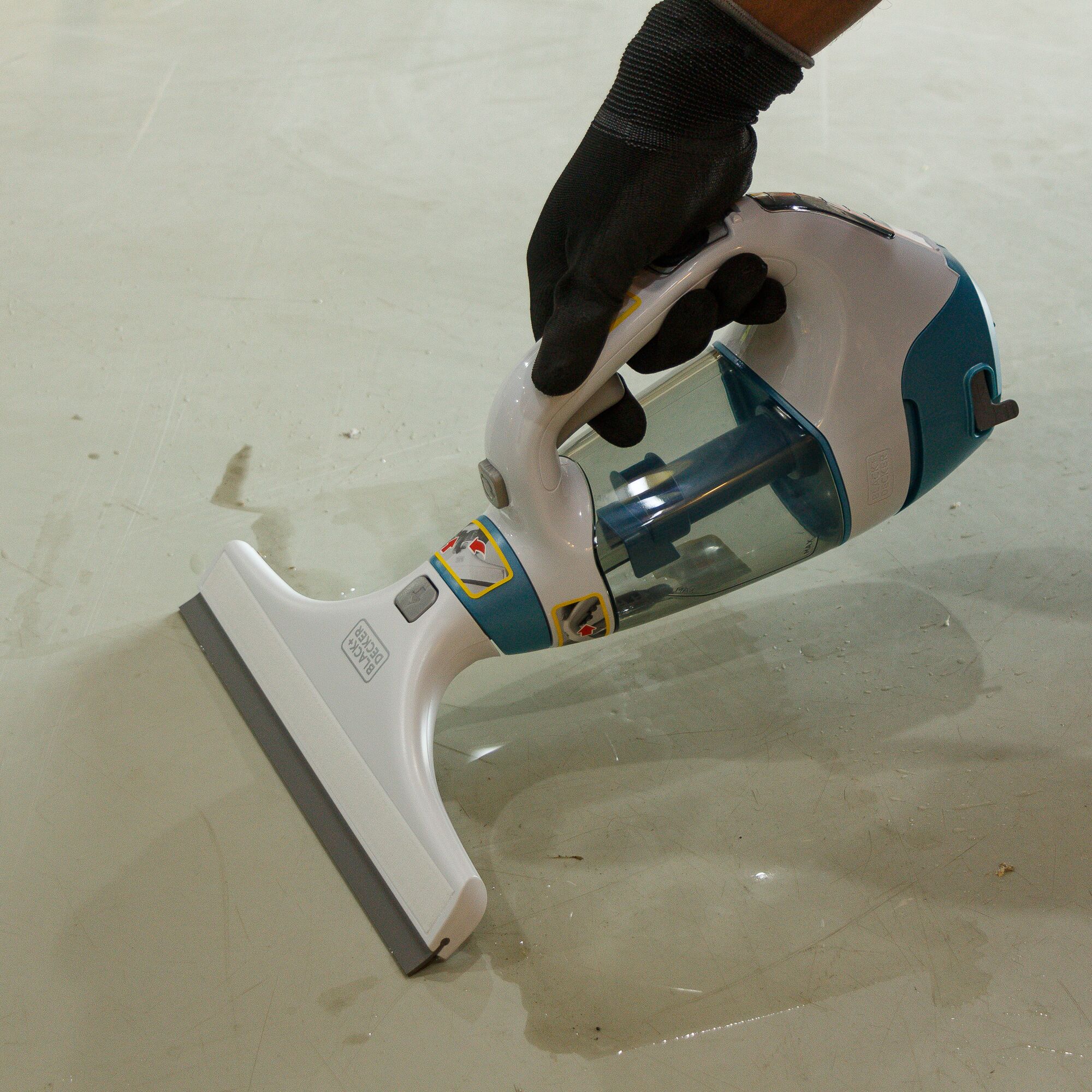 Photo of BLACKDECKER WW100 handheld wet vacuum cleaner in use on a wet floor.